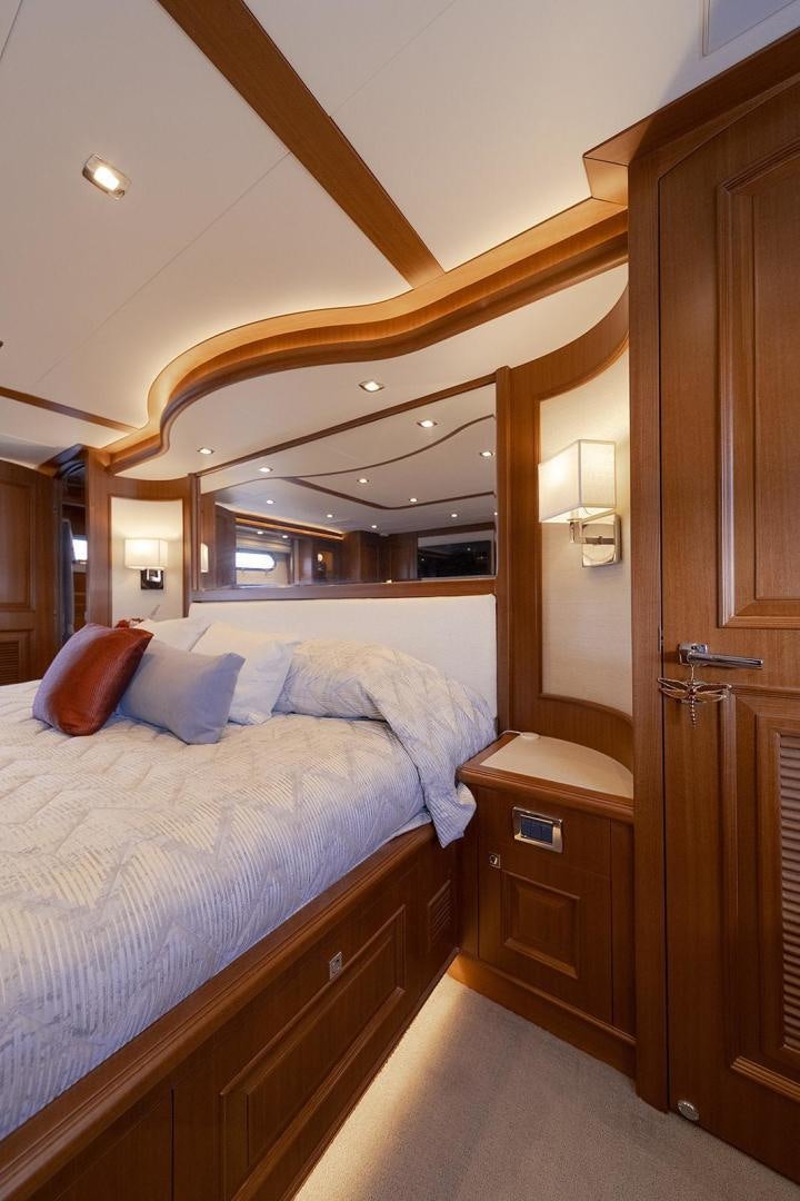 a bedroom with a bed and a mirror aboard PARADISE Yacht for Sale