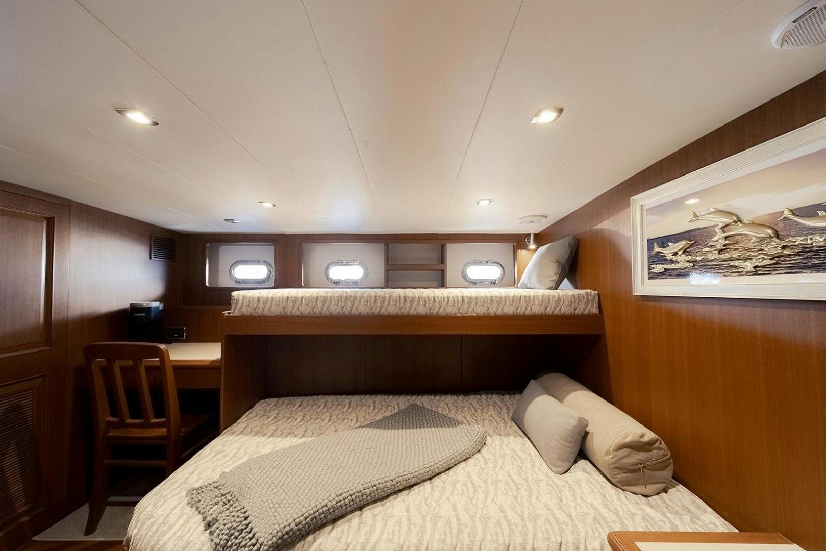 a bedroom with a bed and a desk aboard PARADISE Yacht for Sale