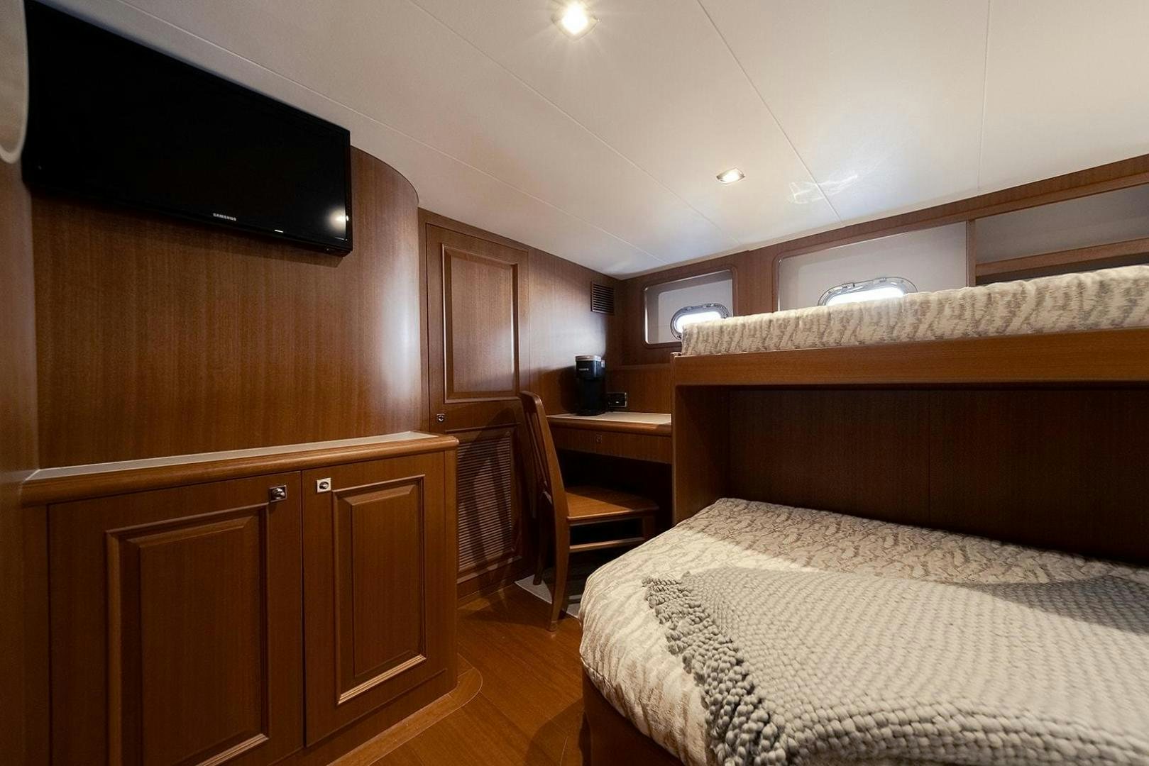 a bedroom with a bed and a tv aboard PARADISE Yacht for Sale