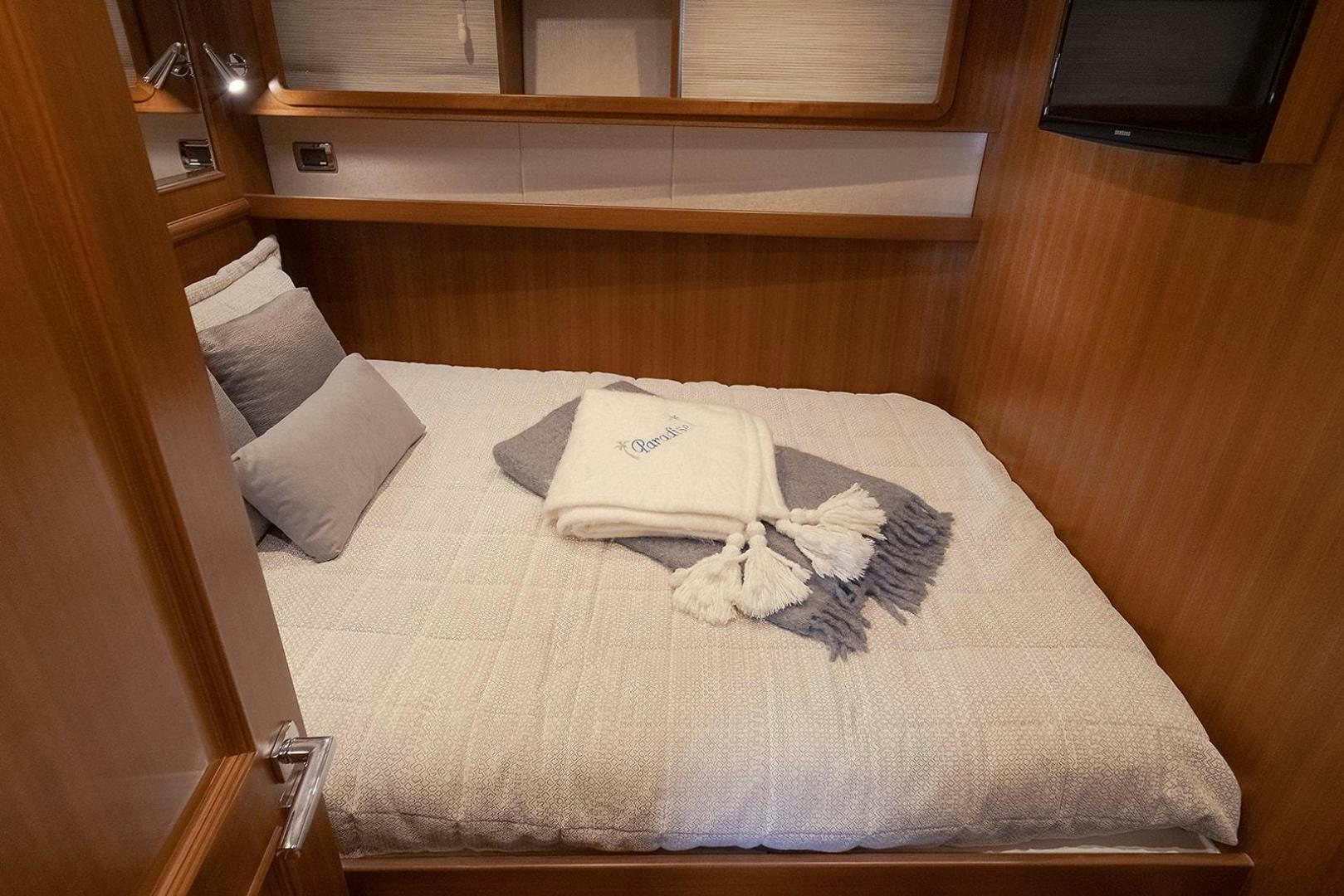 a bed with a white pillow and a white blanket on it aboard PARADISE Yacht for Sale