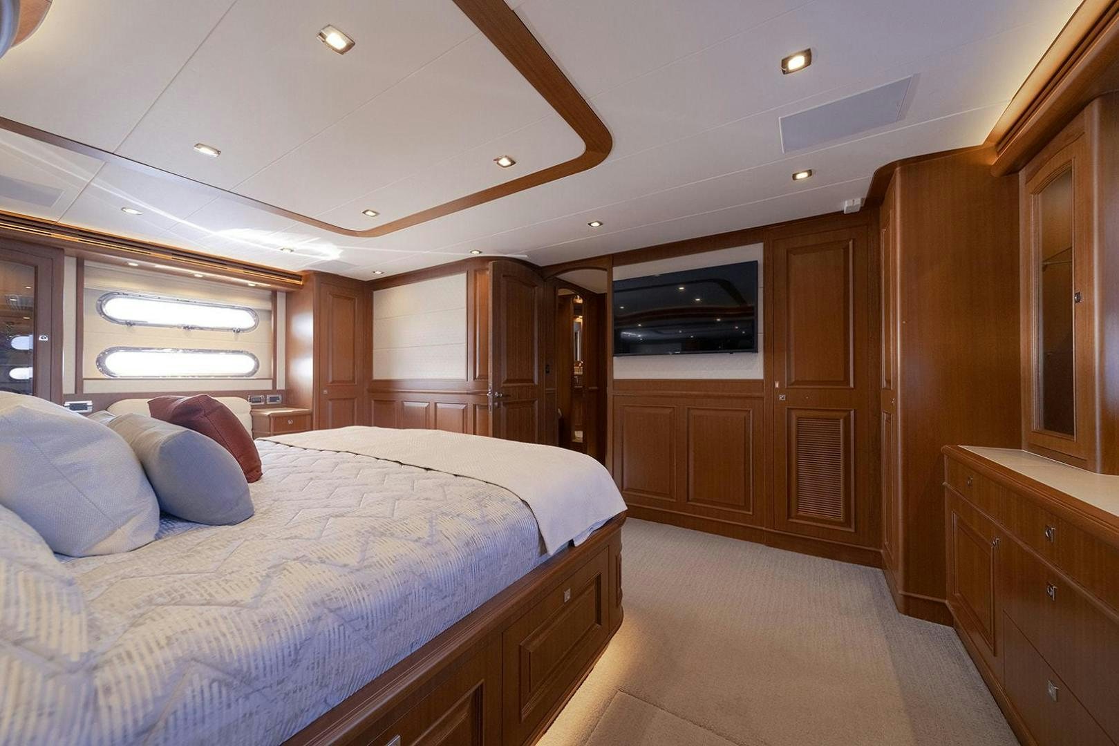 a bedroom with a bed and a wood cabinet aboard PARADISE Yacht for Sale
