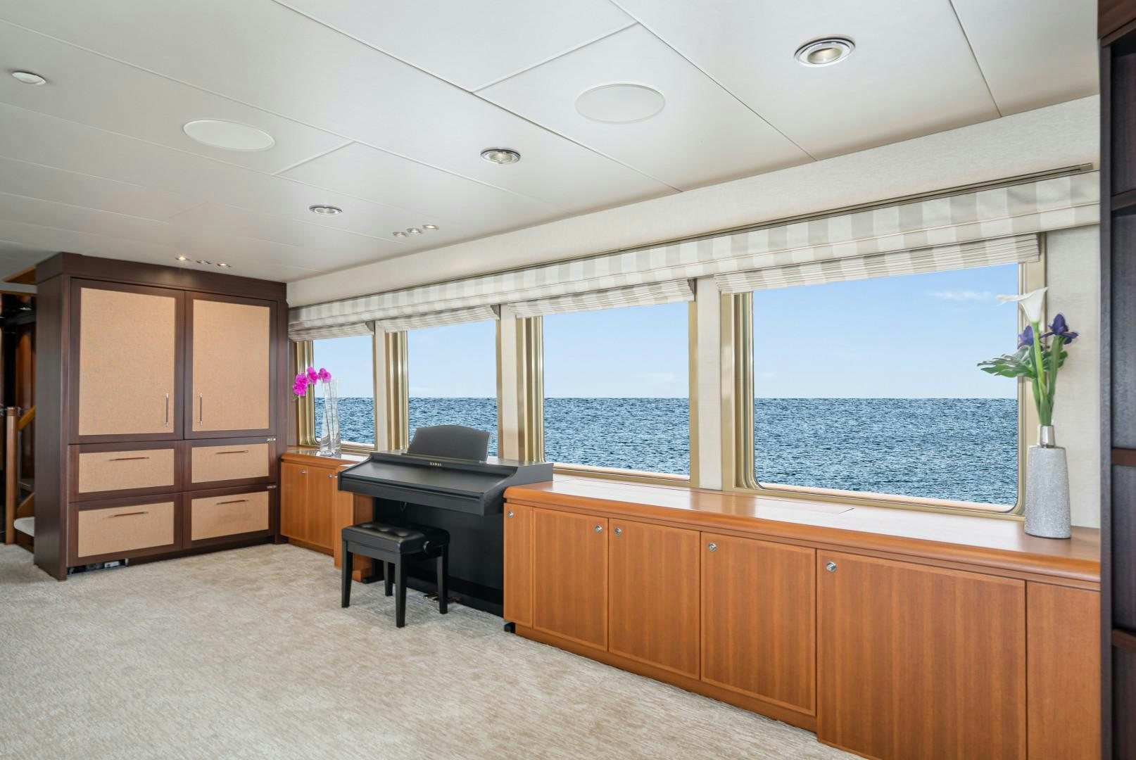 a room with a piano and a large window aboard AFTERGLOW Yacht for Sale