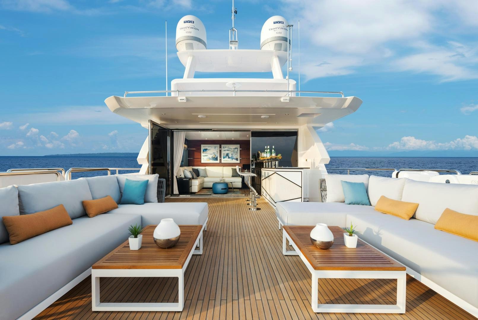 a room with a couch and a table and a large white building with a view of the ocean aboard FD90 229 Yacht for Sale