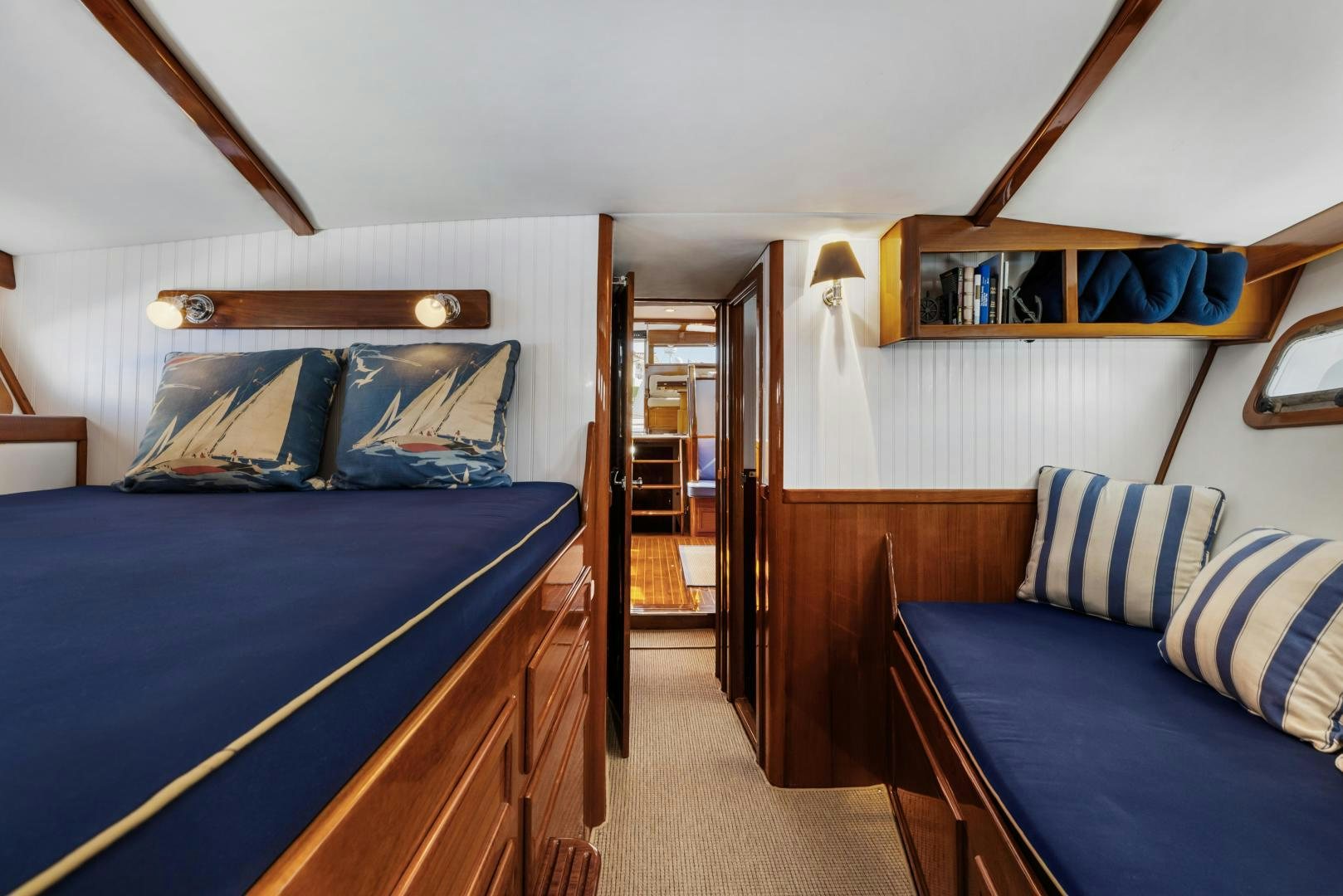 a bedroom with a blue bed and a wood door aboard SILVER OAK Yacht for Sale