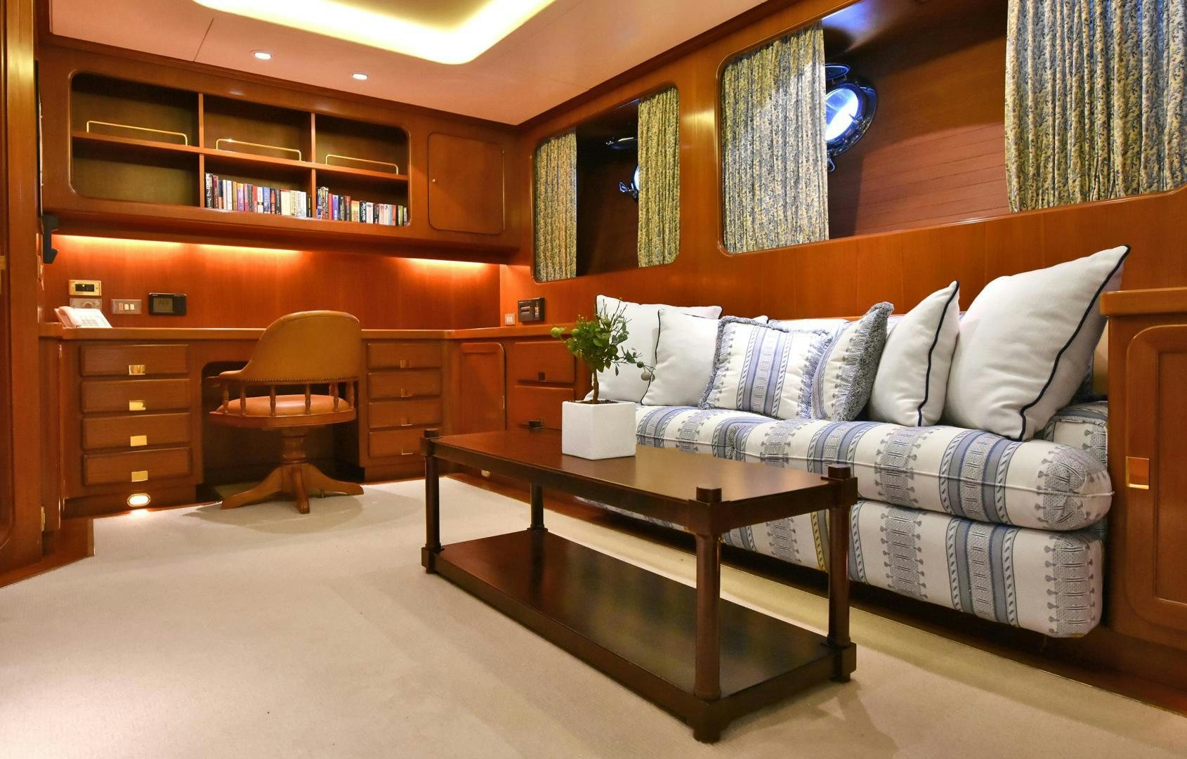 a living room with a couch and coffee table aboard TAMARITA Yacht for Sale