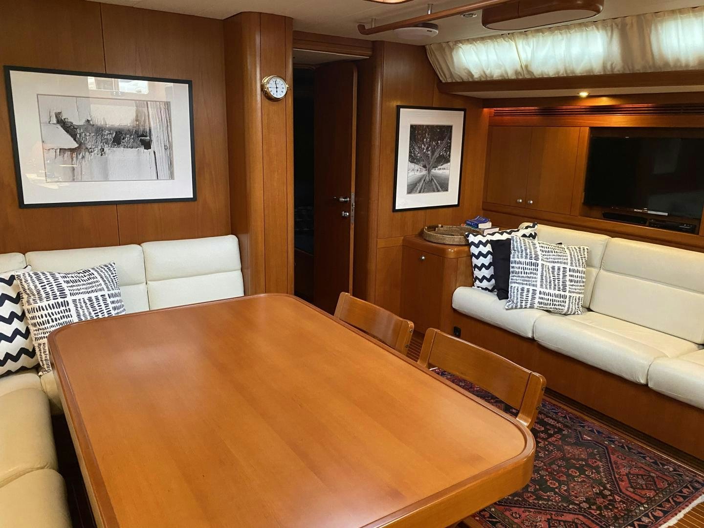 a living room with a table and couches aboard INDIGO VII Yacht for Sale
