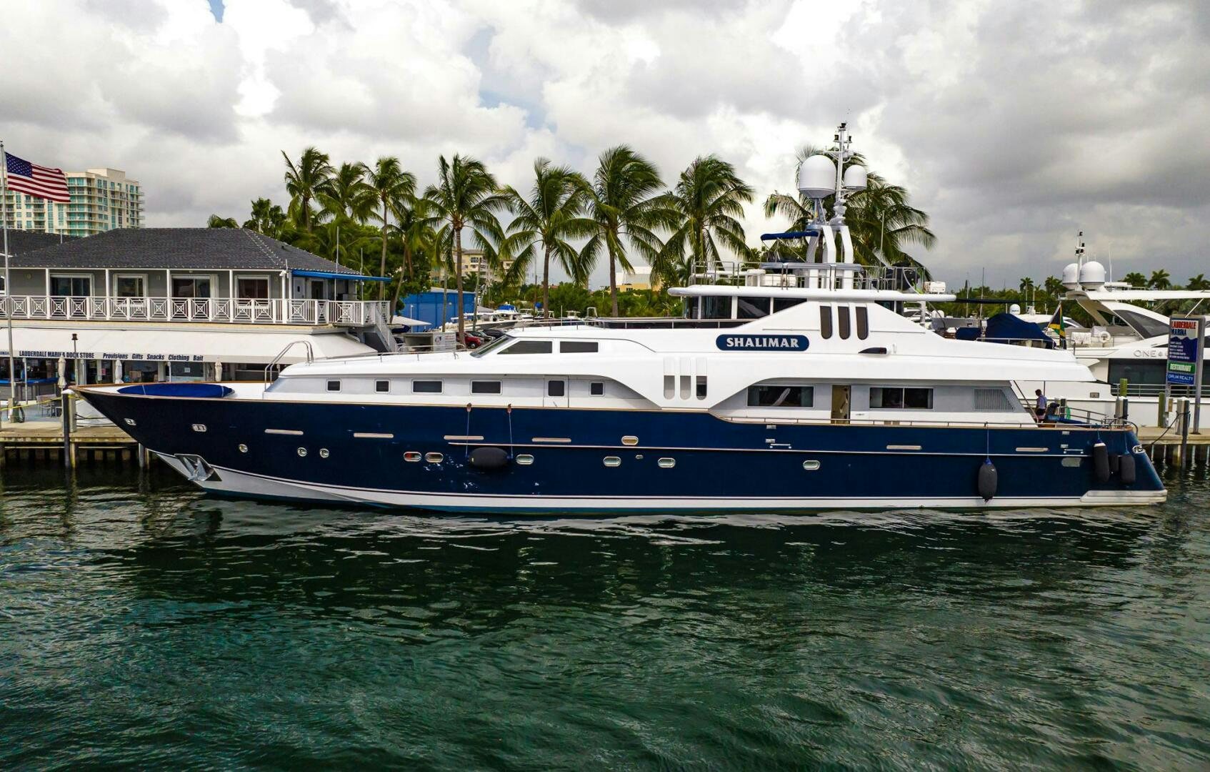 a large white boat in a harbor aboard SHALIMAR Yacht for Sale