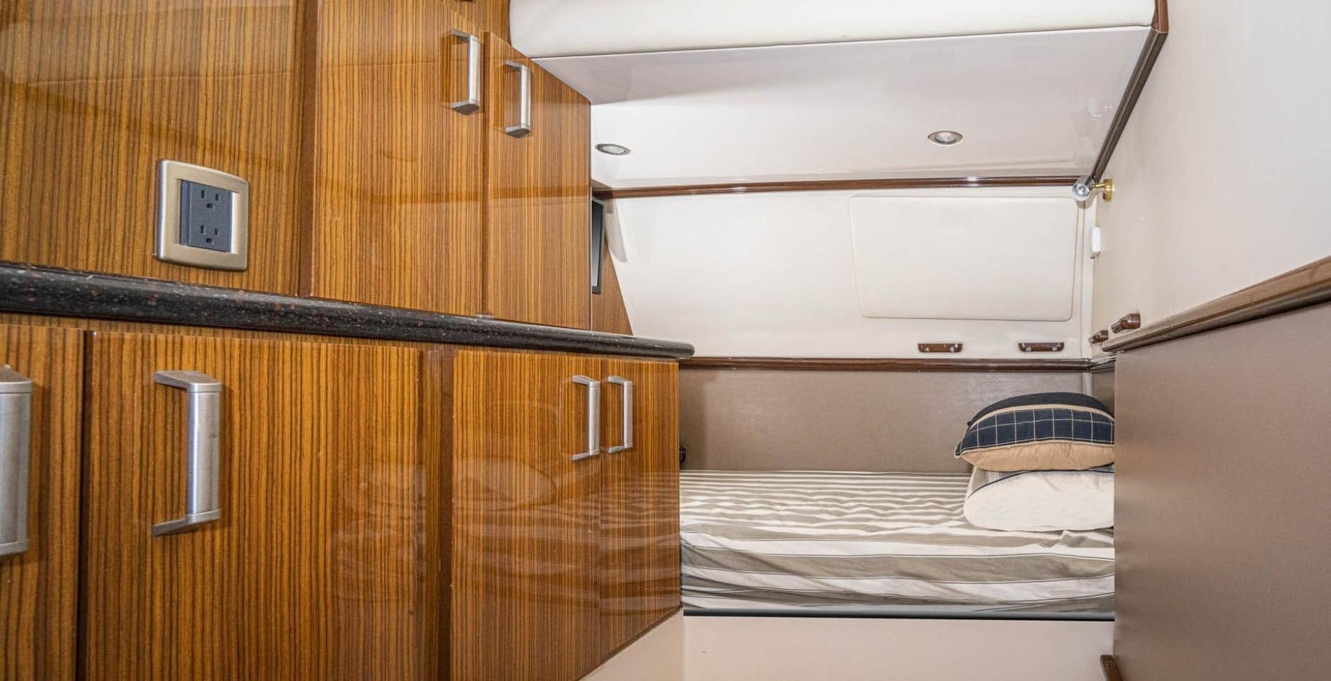 a room with a bed and a cupboard aboard AWAKEN Yacht for Sale