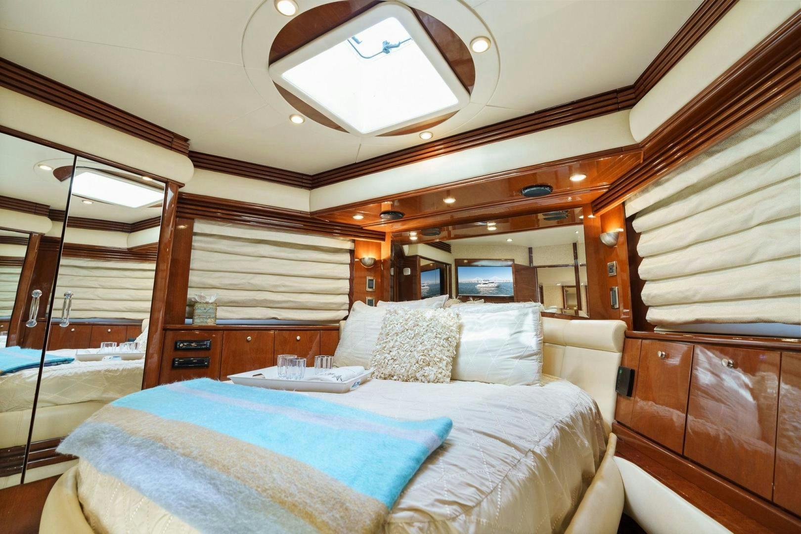 a bed with a chair and a mirror in a room aboard LA BELLA VITA Yacht for Sale