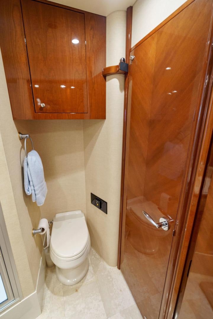 a bathroom with a toilet and wooden cabinets aboard LA BELLA VITA Yacht for Sale