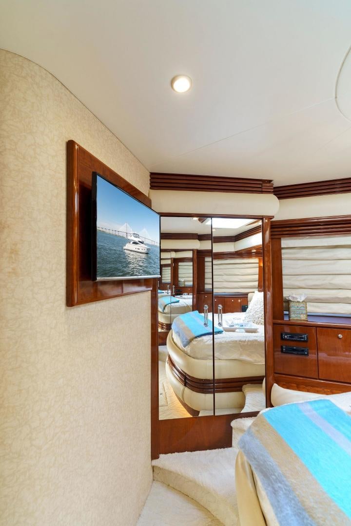 a bedroom with a television on the wall aboard LA BELLA VITA Yacht for Sale