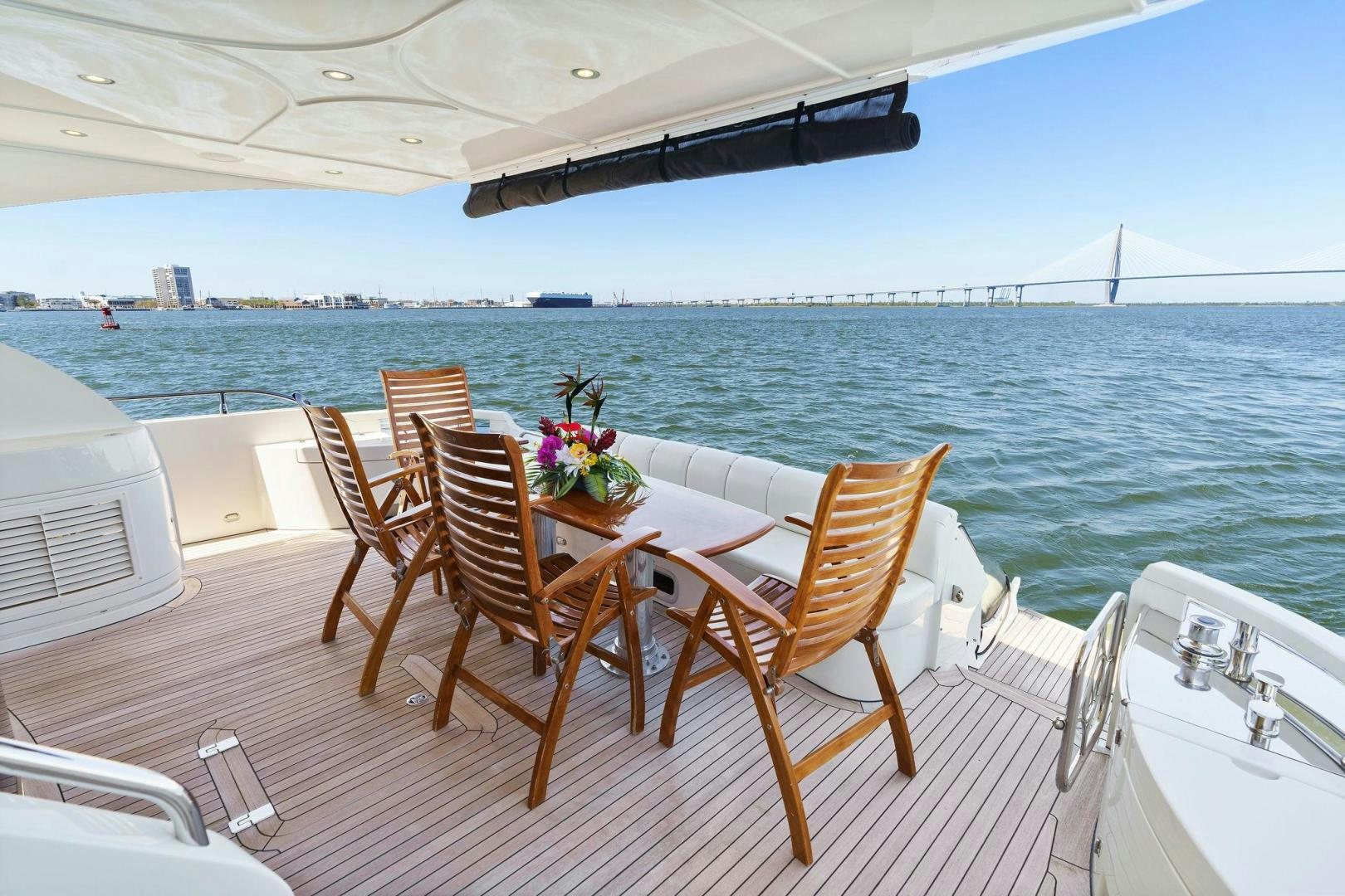 a table and chairs on a deck overlooking a body of water aboard LA BELLA VITA Yacht for Sale