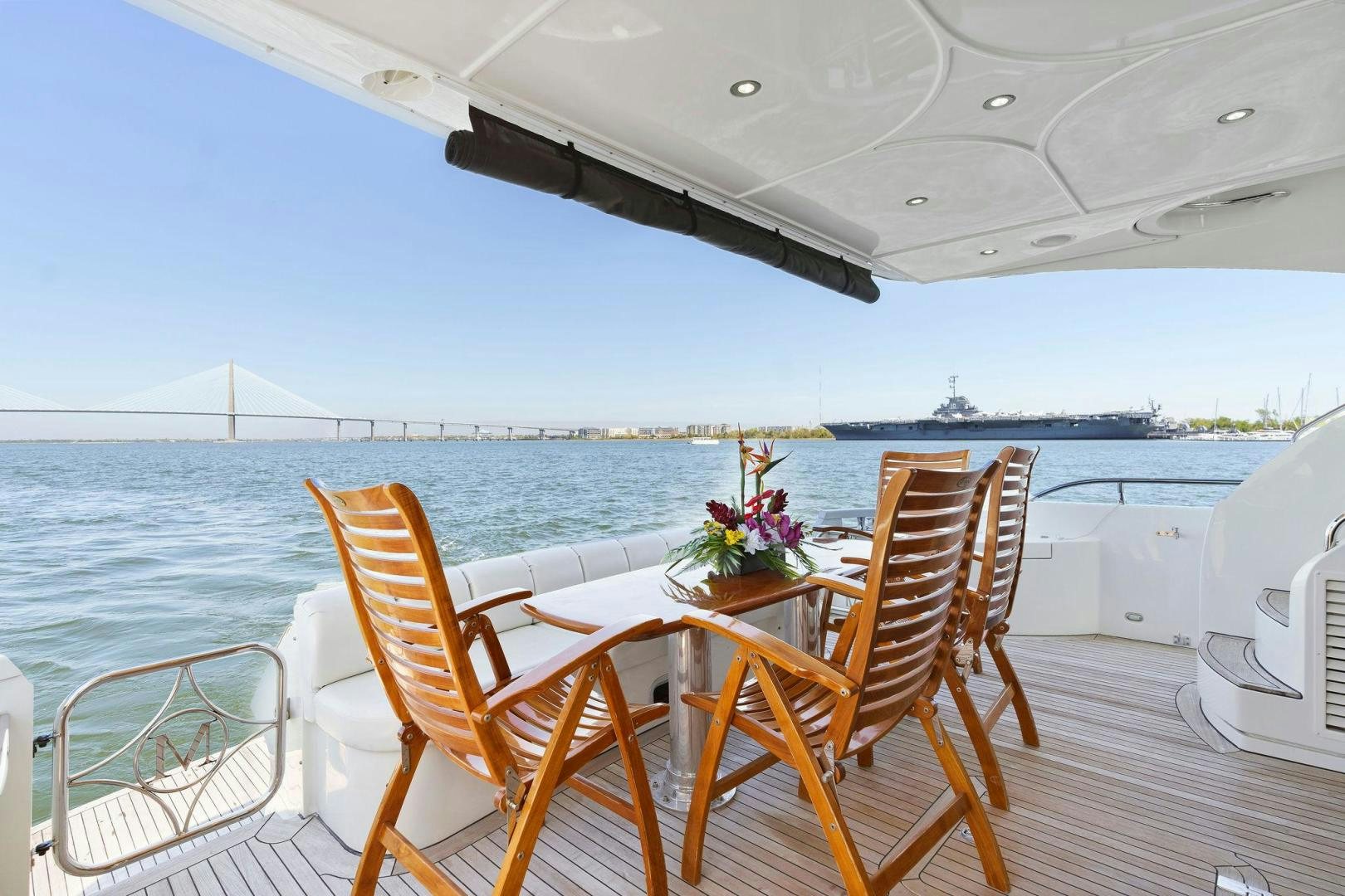 a table and chairs on a deck overlooking a body of water aboard LA BELLA VITA Yacht for Sale