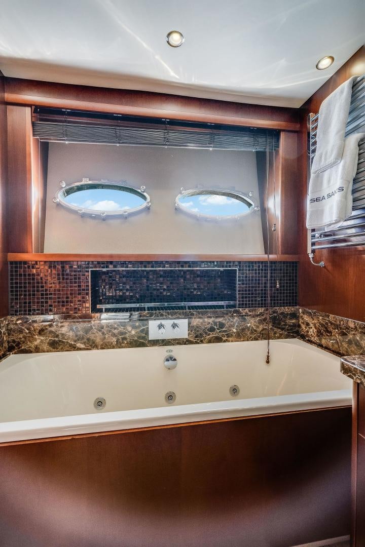 a bathroom with a bathtub and a tile wall aboard 21 SEA SANDS Yacht for Sale