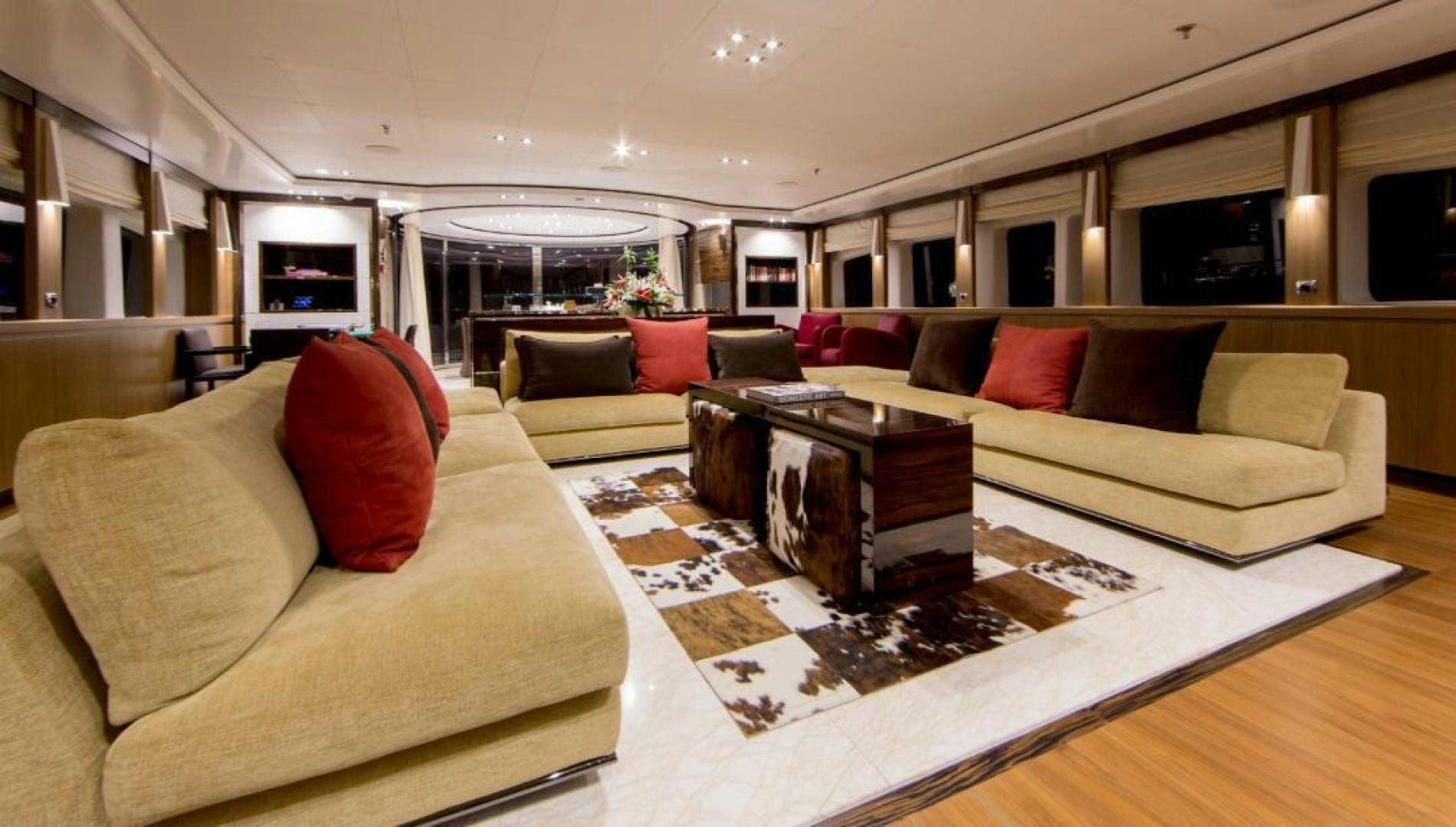 a living room with a large sofa and a coffee table aboard PANAKEIA Yacht for Charter