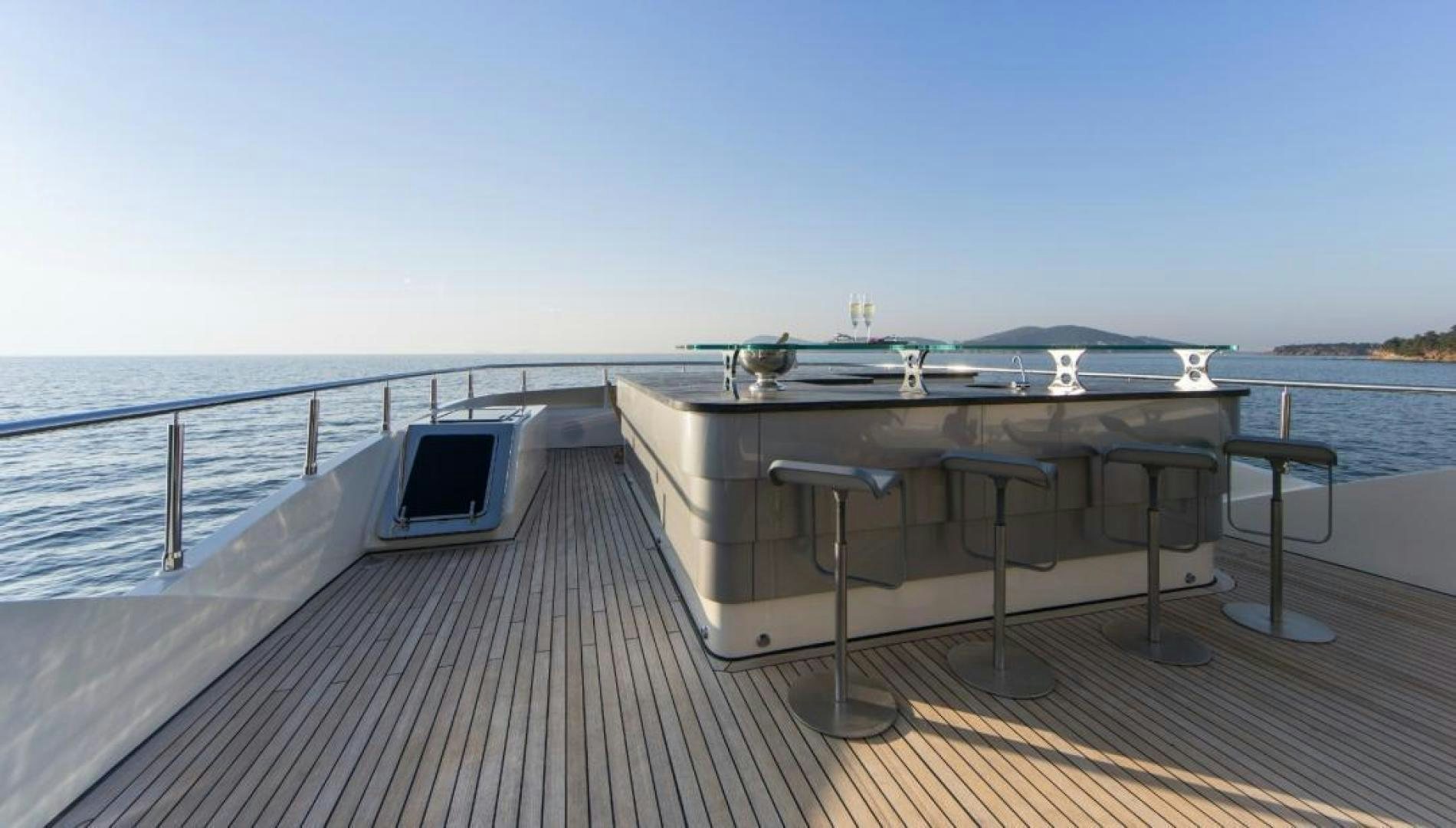 a deck with a table and chairs on it aboard PANAKEIA Yacht for Charter