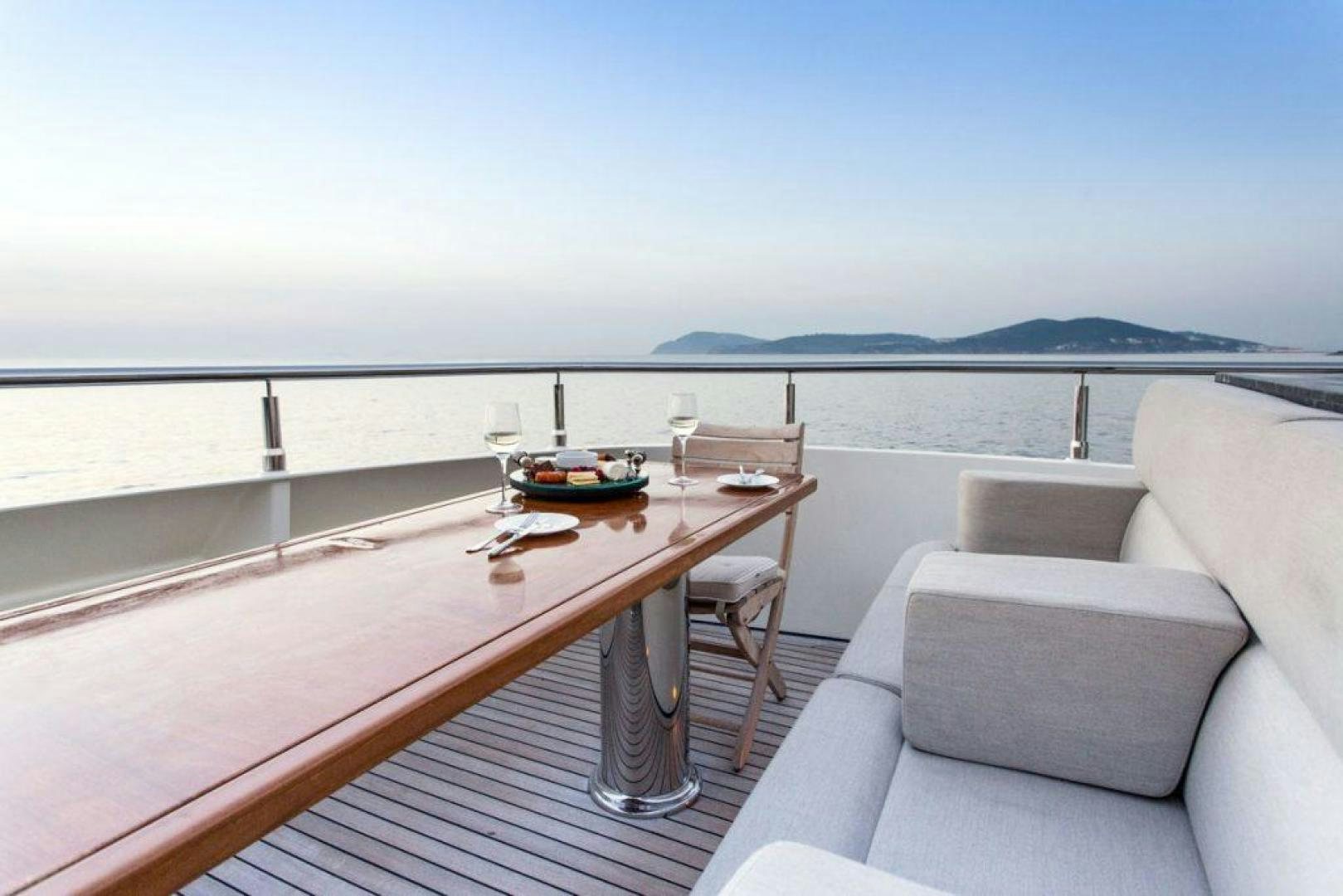 a table on a deck overlooking the ocean aboard PANAKEIA Yacht for Charter