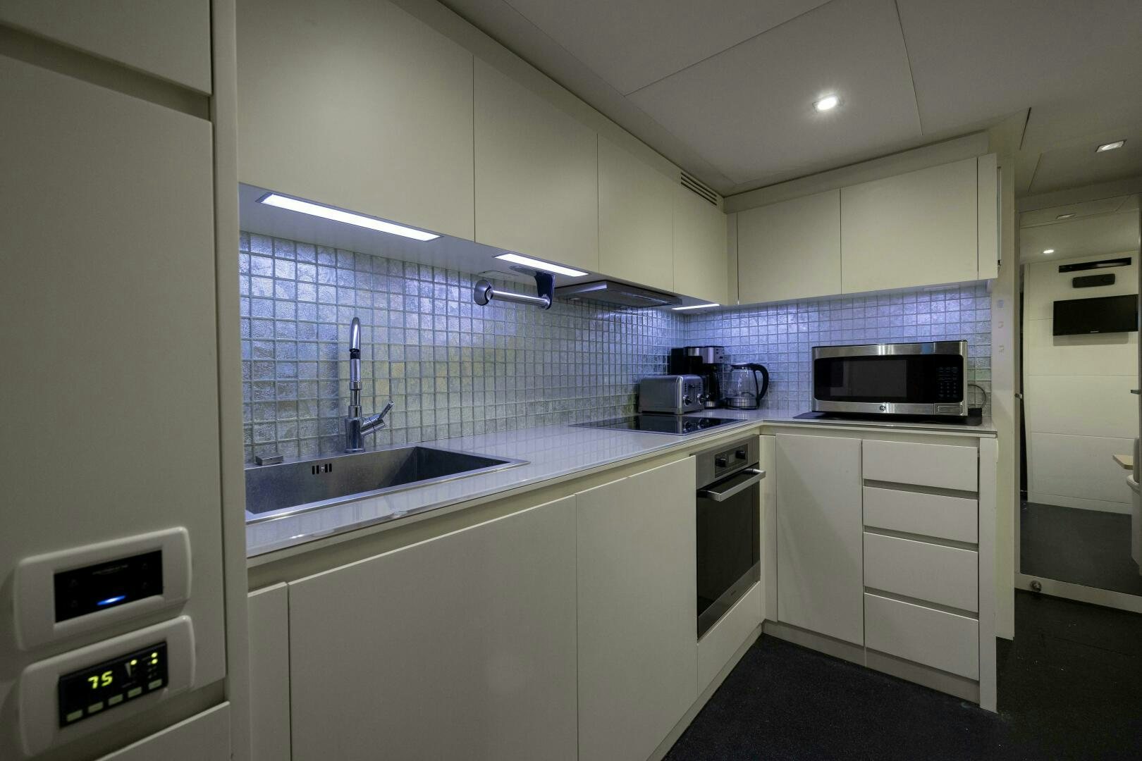 a kitchen with white cabinets aboard MILAGROS Yacht for Sale