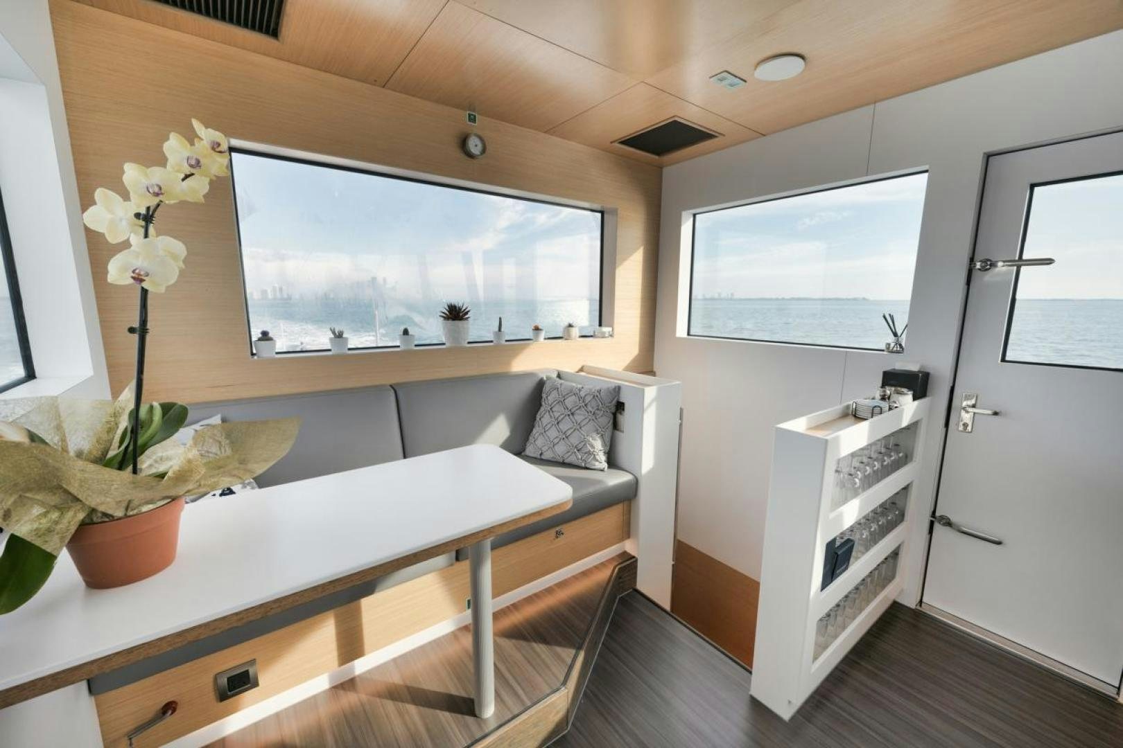 a living room with a table and a tv aboard NANAN SHADOW Yacht for Sale