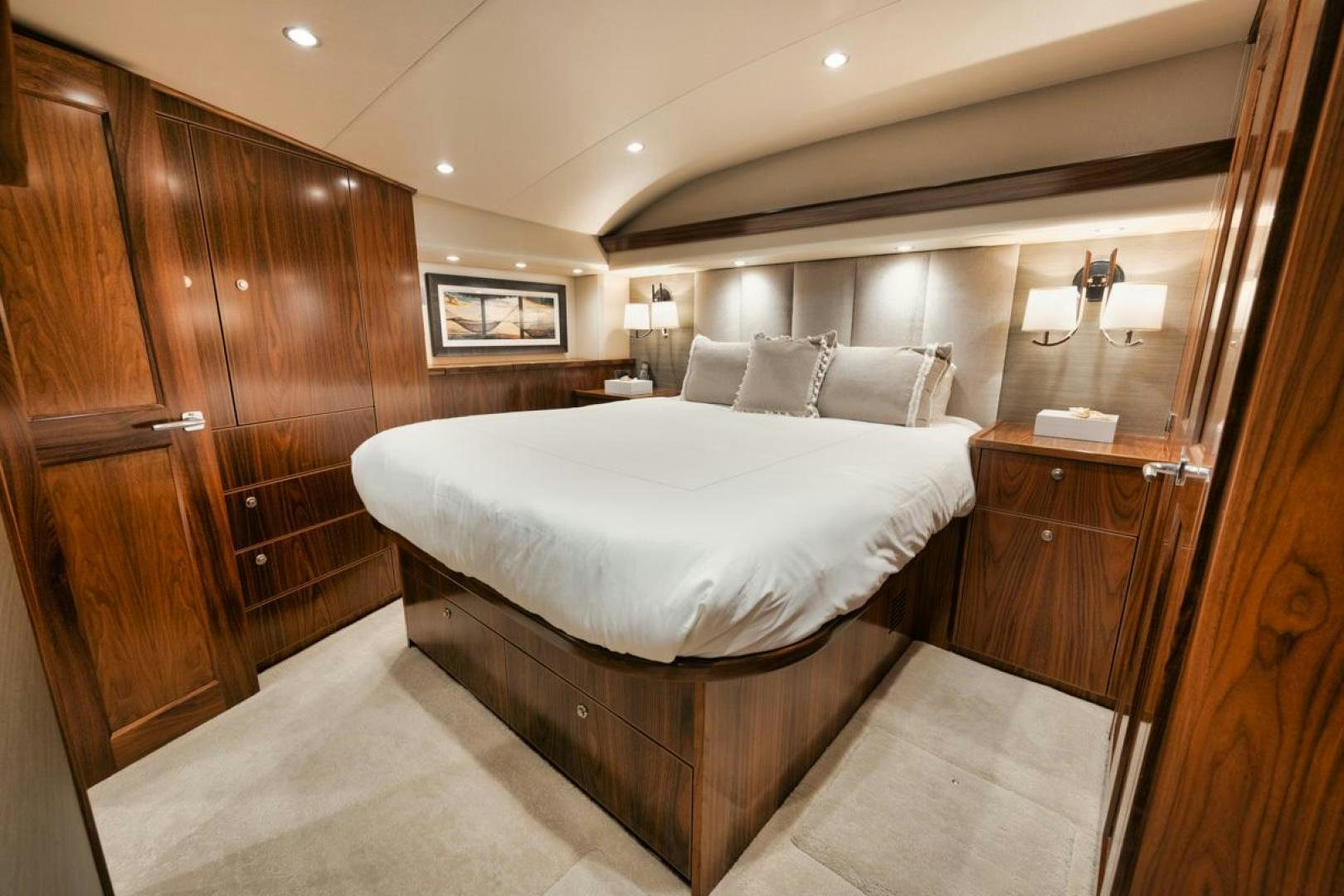 a bedroom with a bed and a wood cabinet aboard MADNIC Yacht for Sale