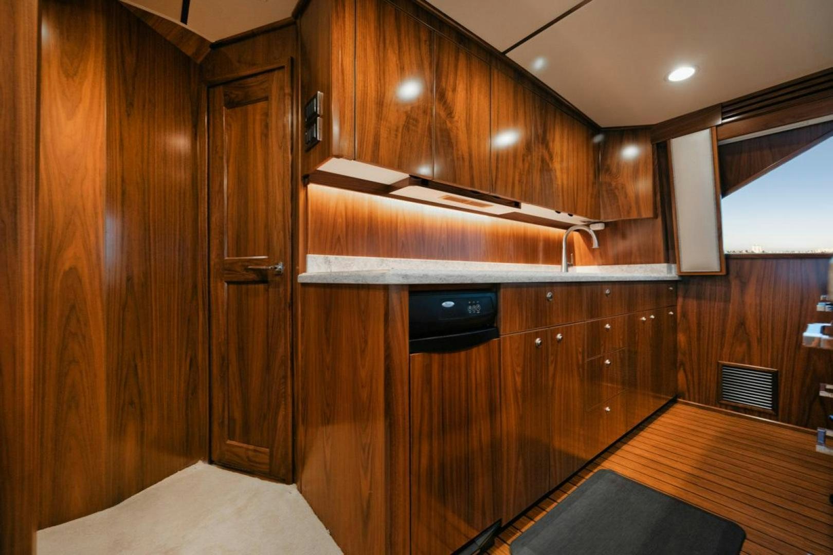 a wooden kitchen with wooden cabinets aboard MADNIC Yacht for Sale