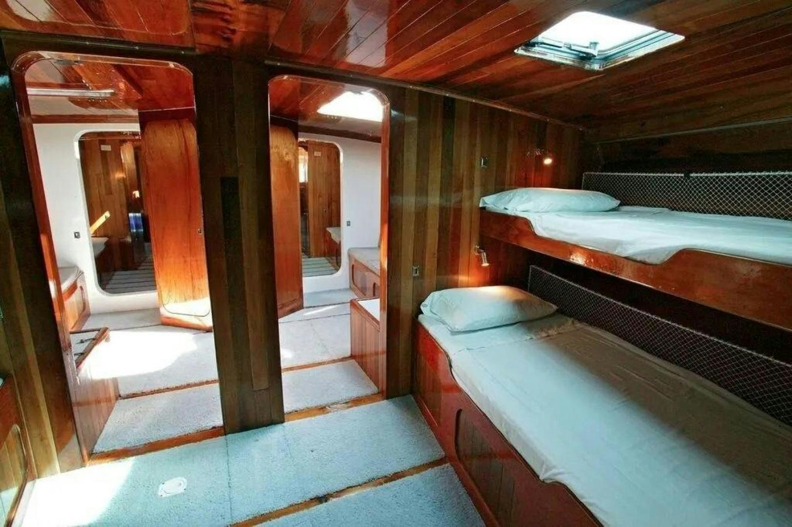 a room with beds and a door aboard CHRISTINE Yacht for Sale