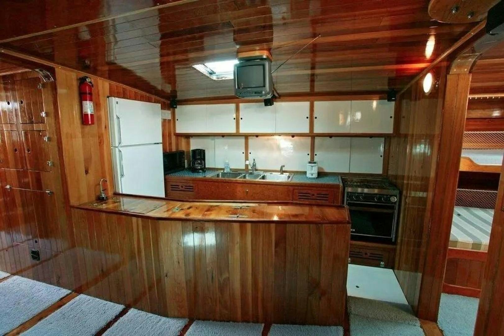 a kitchen with wooden cabinets aboard CHRISTINE Yacht for Sale