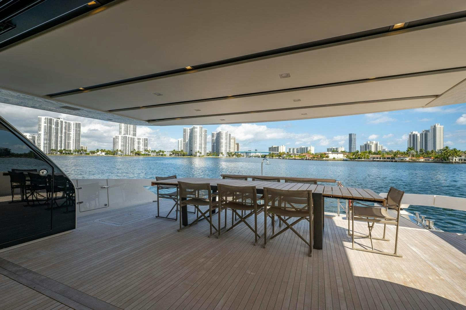 a group of tables and chairs on a deck by a body of water aboard ABOUT TIME Yacht for Sale