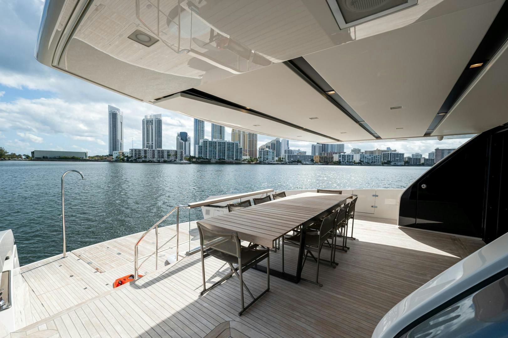 a deck with a table and chairs on it aboard ABOUT TIME Yacht for Sale