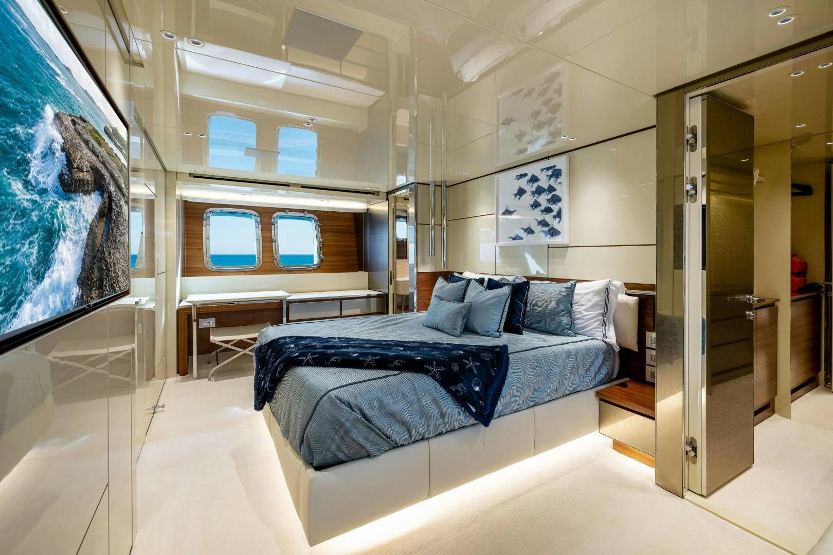 a room with a bed and a painting on the wall aboard ABOUT TIME Yacht for Sale