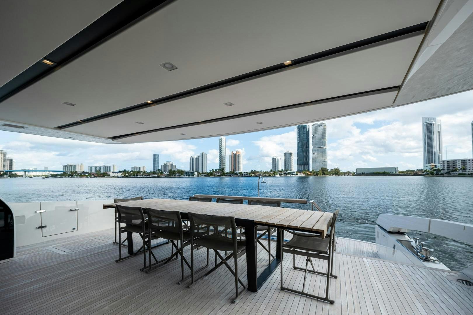 a table and chairs on a deck overlooking a city aboard ABOUT TIME Yacht for Sale