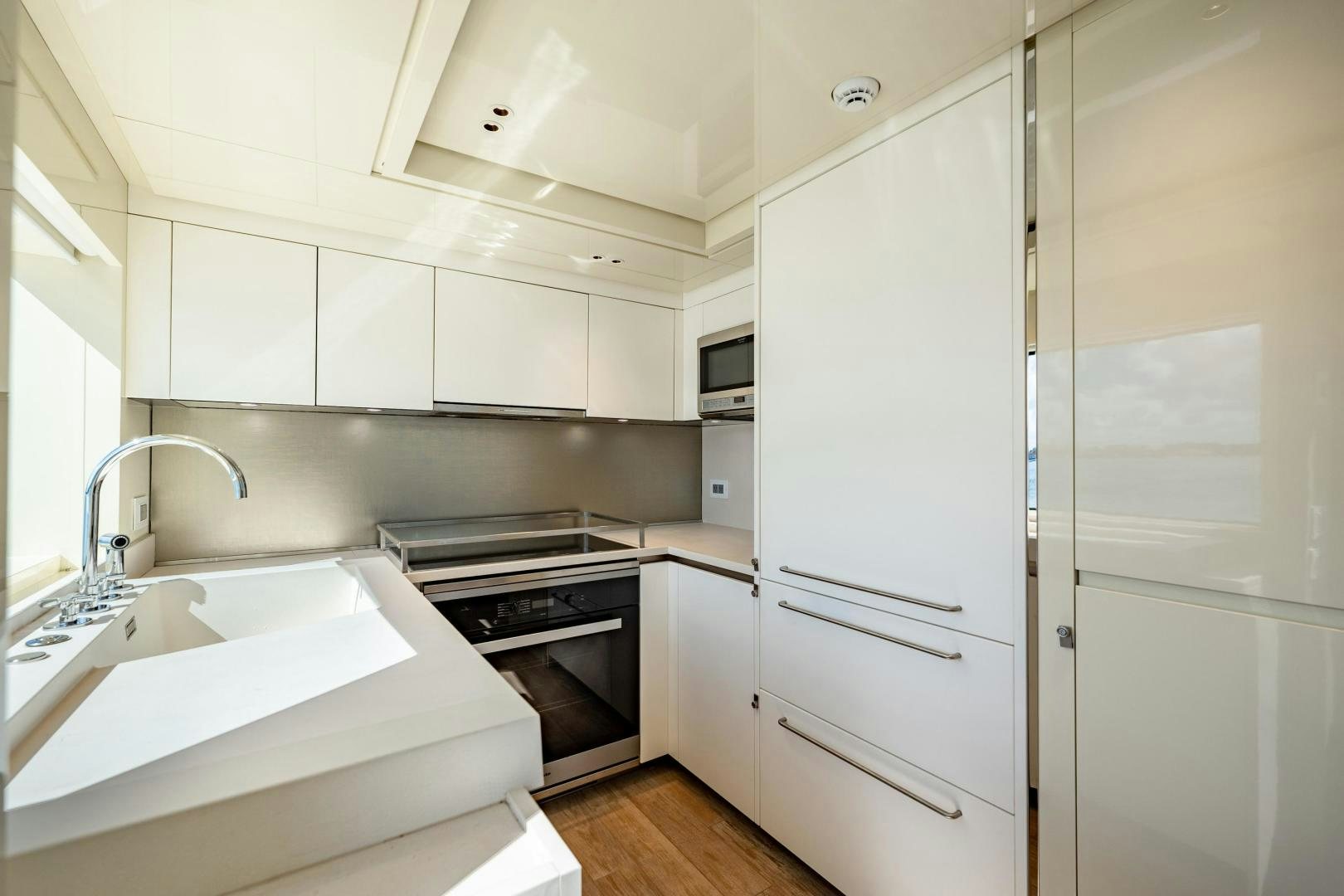a kitchen with white cabinets aboard ABOUT TIME Yacht for Sale