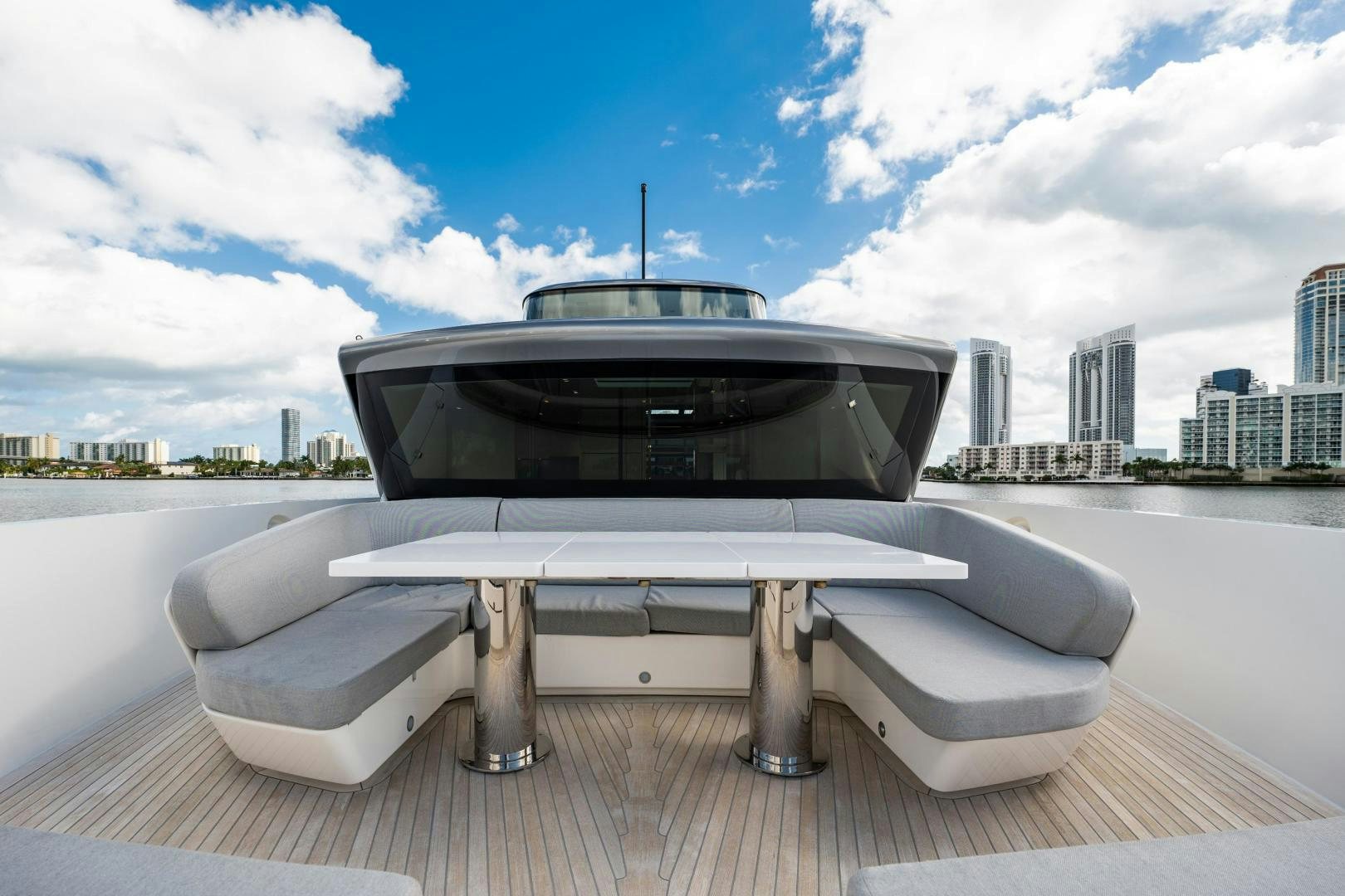 a white rectangular table with a black screen on a wooden surface with a city in the background aboard ABOUT TIME Yacht for Sale