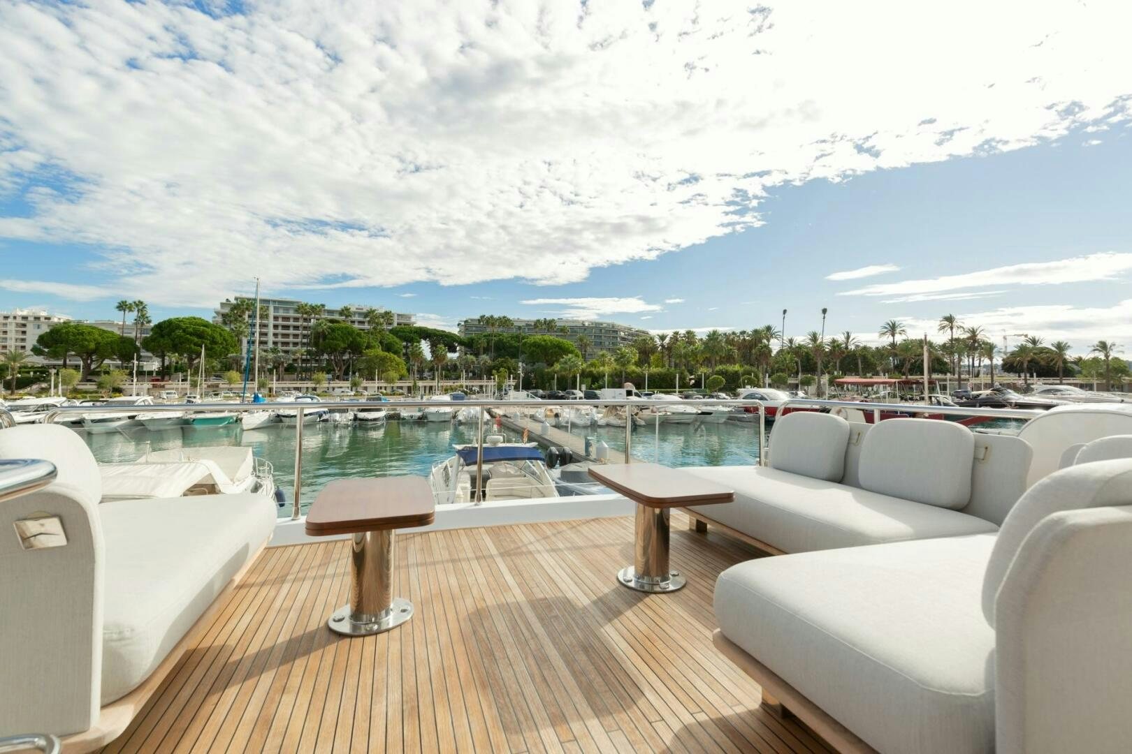 a deck with chairs and tables on it by a body of water aboard SOLSTICE Yacht for Sale