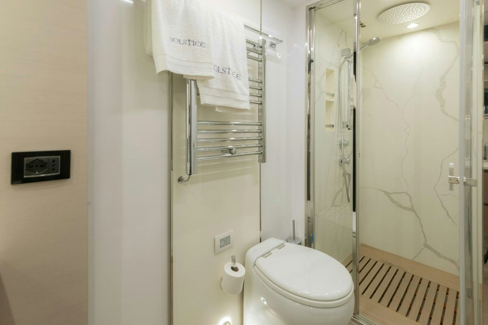 a bathroom with a toilet and a shower unit aboard SOLSTICE Yacht for Sale
