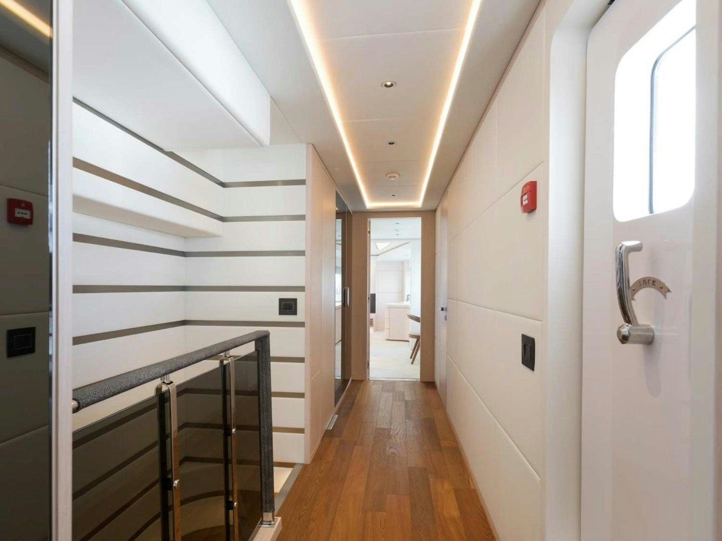 a hallway with a door and a ladder aboard OCEAN VIEW Yacht for Sale