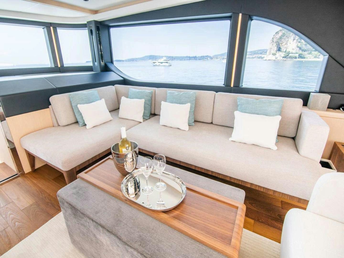 a couch with a glass of wine and a table with a view of the ocean aboard OCEAN VIEW Yacht for Sale
