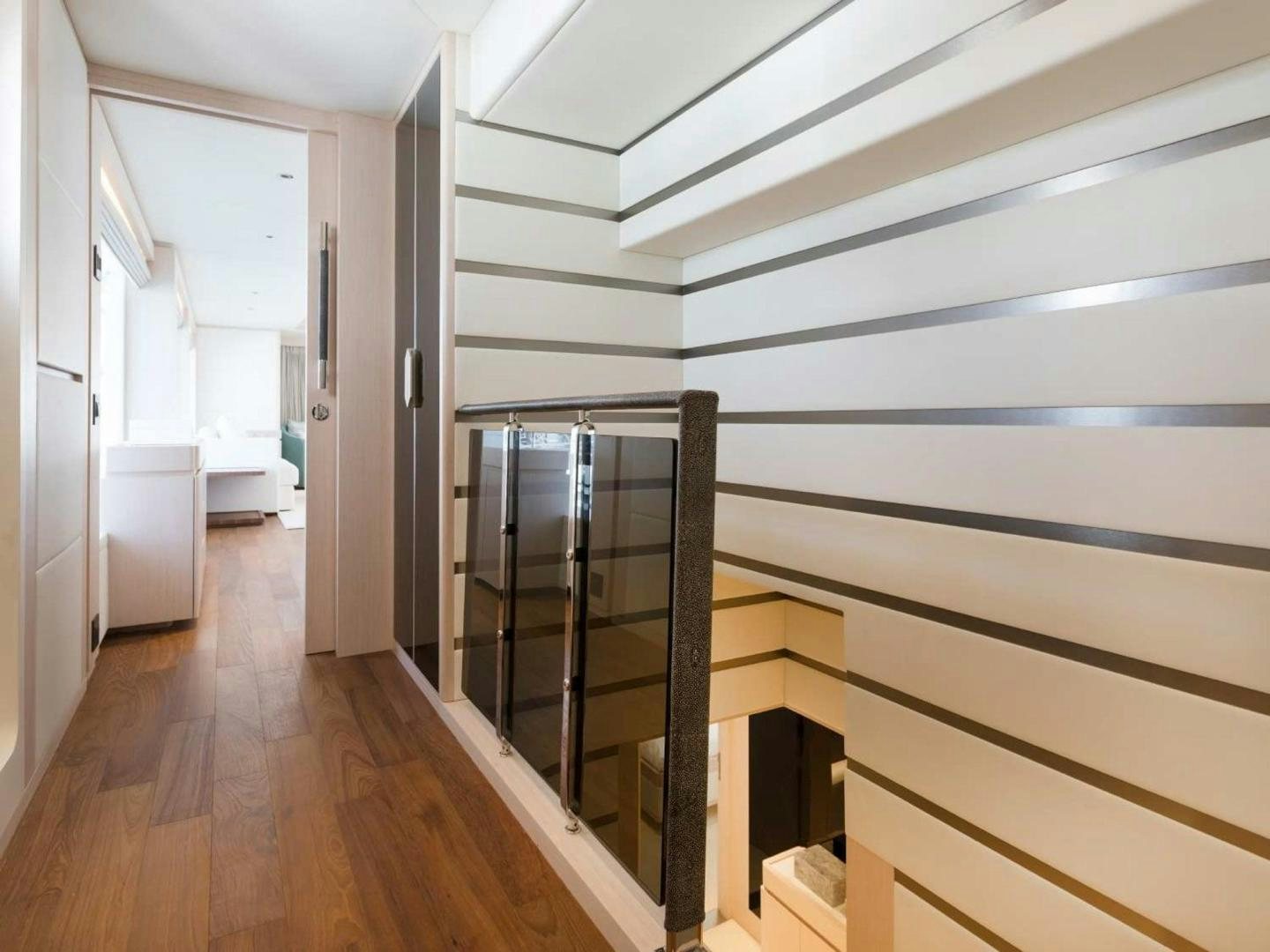 a room with a wood floor and a black railing aboard OCEAN VIEW Yacht for Sale