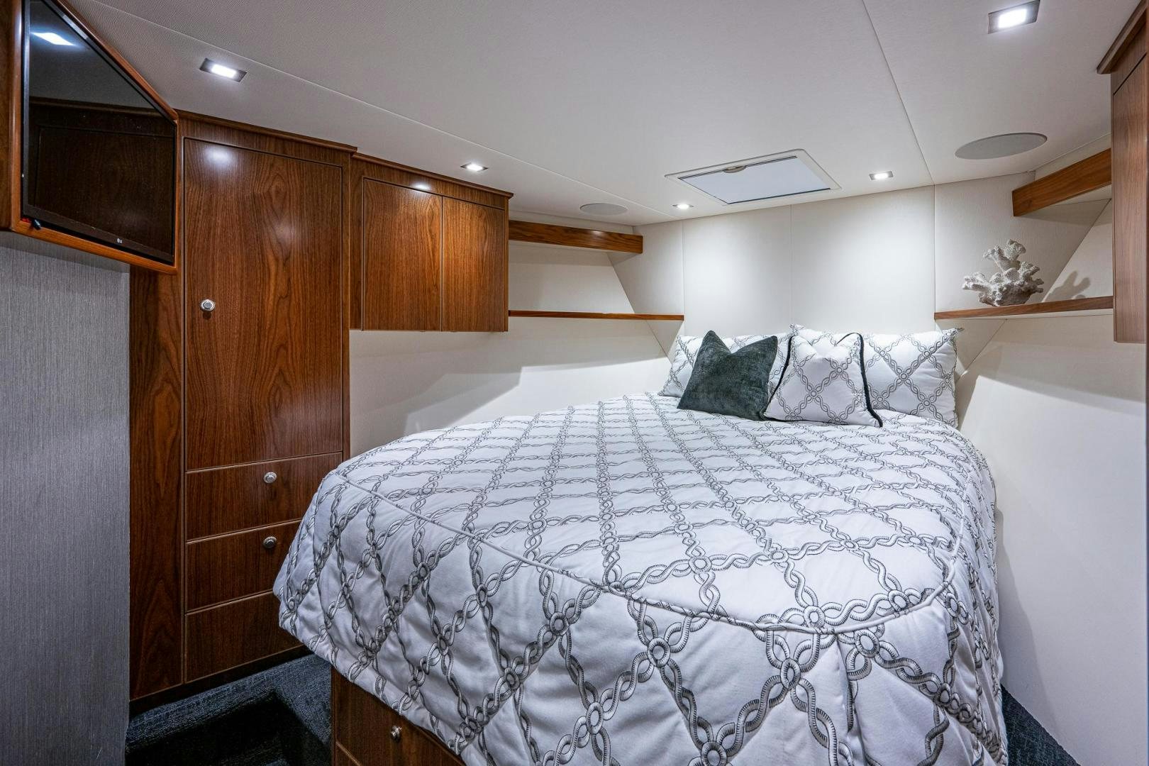 a bedroom with a bed and a wood cabinet aboard KEMOSABE Yacht for Sale