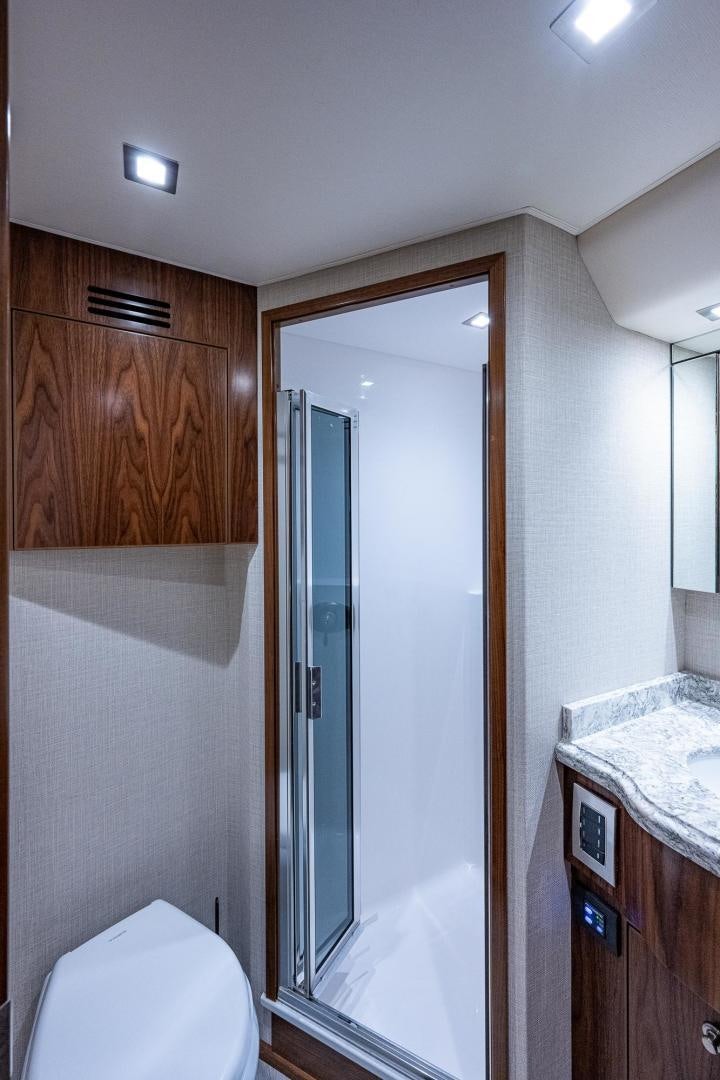 a bathroom with a glass shower aboard KEMOSABE Yacht for Sale