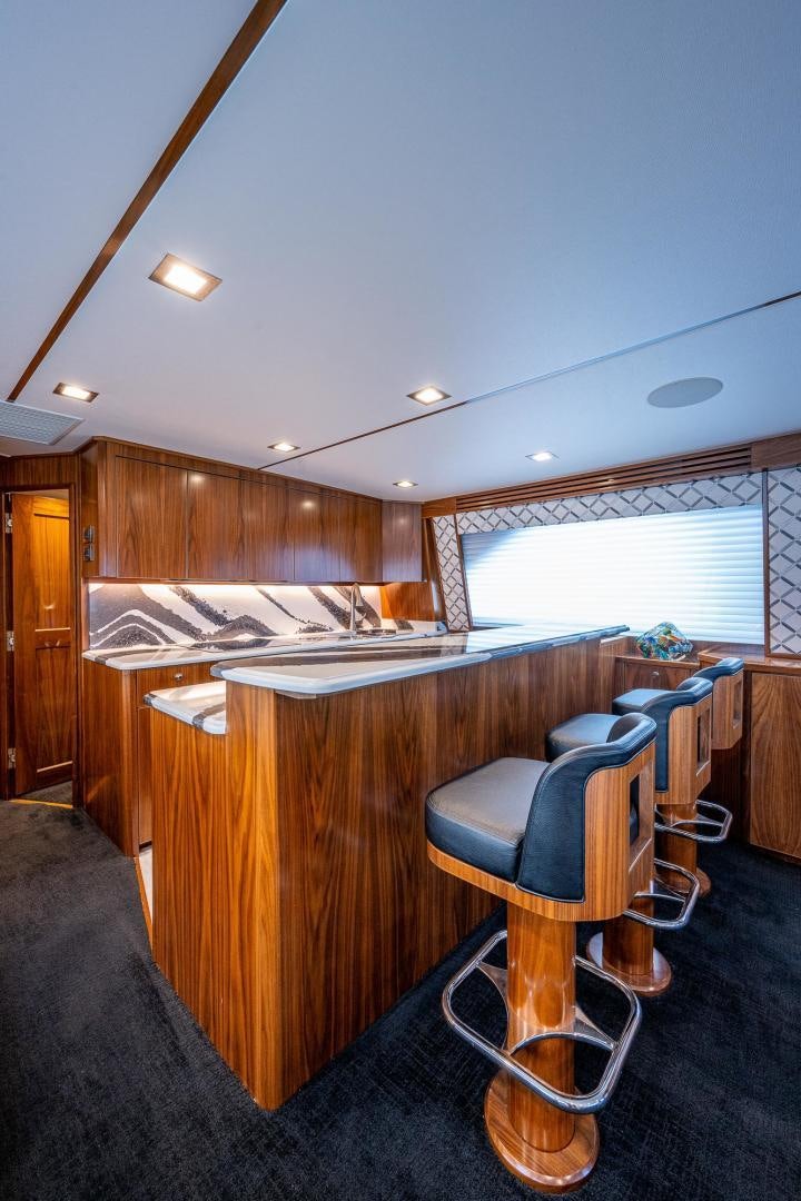 a kitchen with a bar and stools aboard KEMOSABE Yacht for Sale