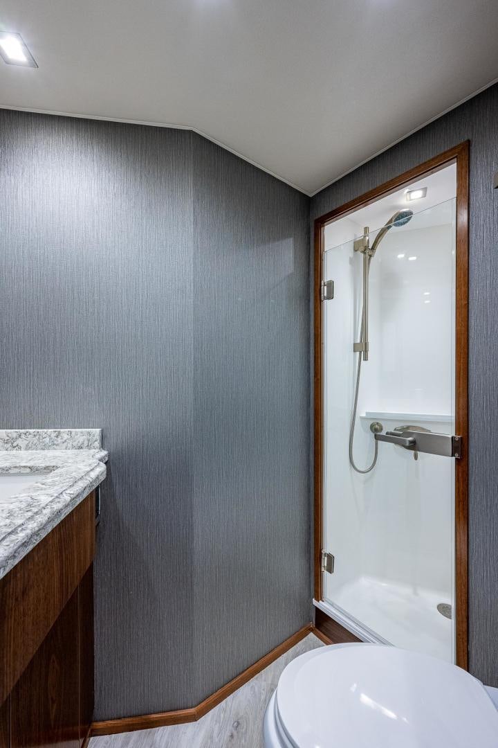 a bathroom with a shower and a toilet aboard KEMOSABE Yacht for Sale