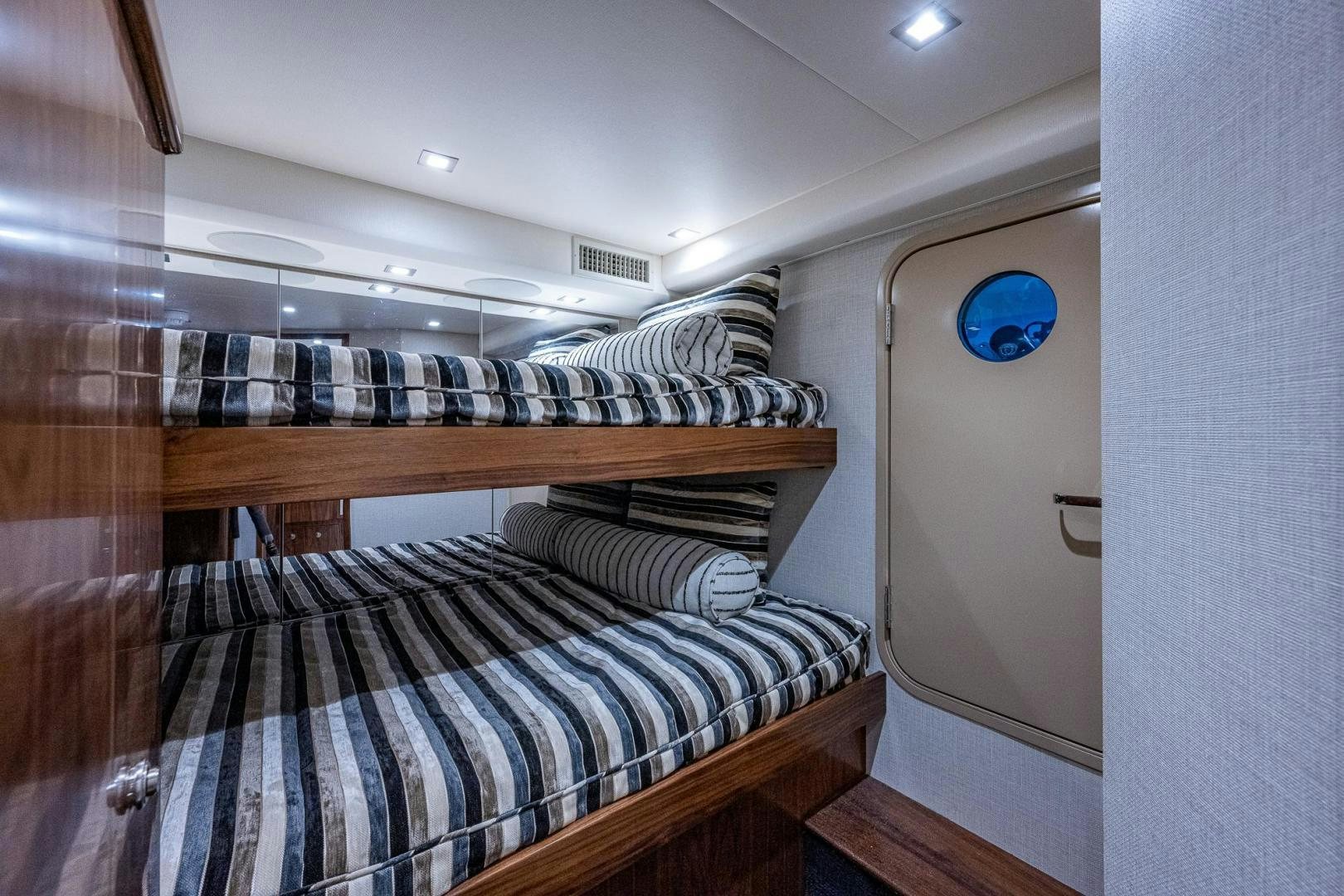 a bed with a striped sheet aboard KEMOSABE Yacht for Sale