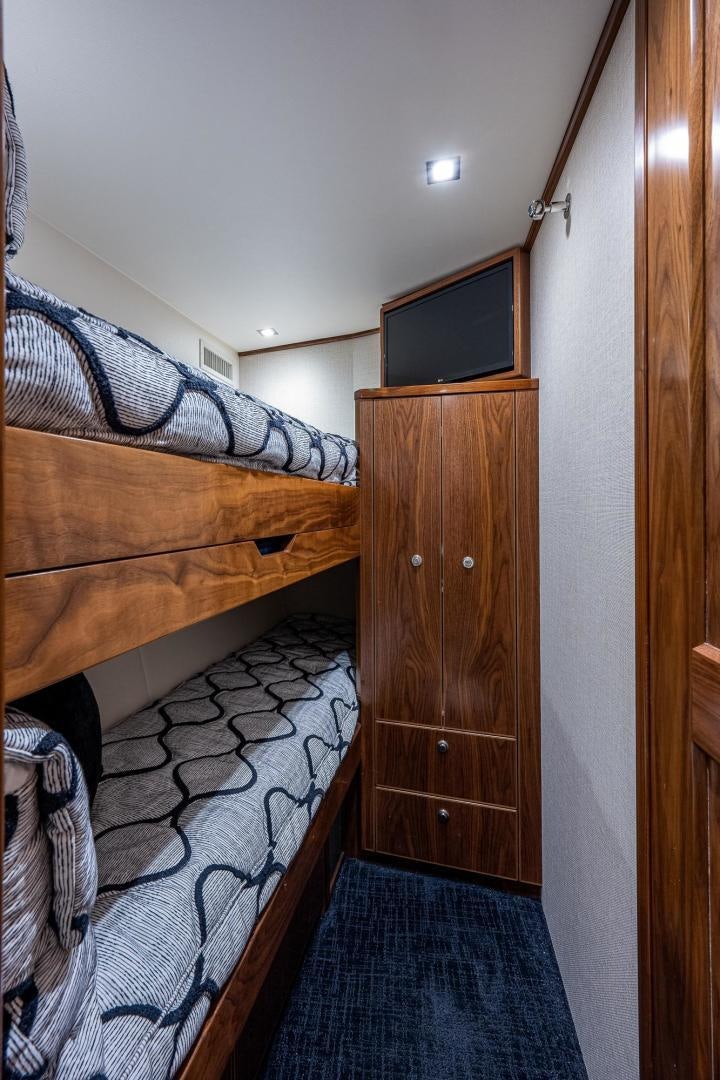 a bedroom with a bed and a television aboard KEMOSABE Yacht for Sale