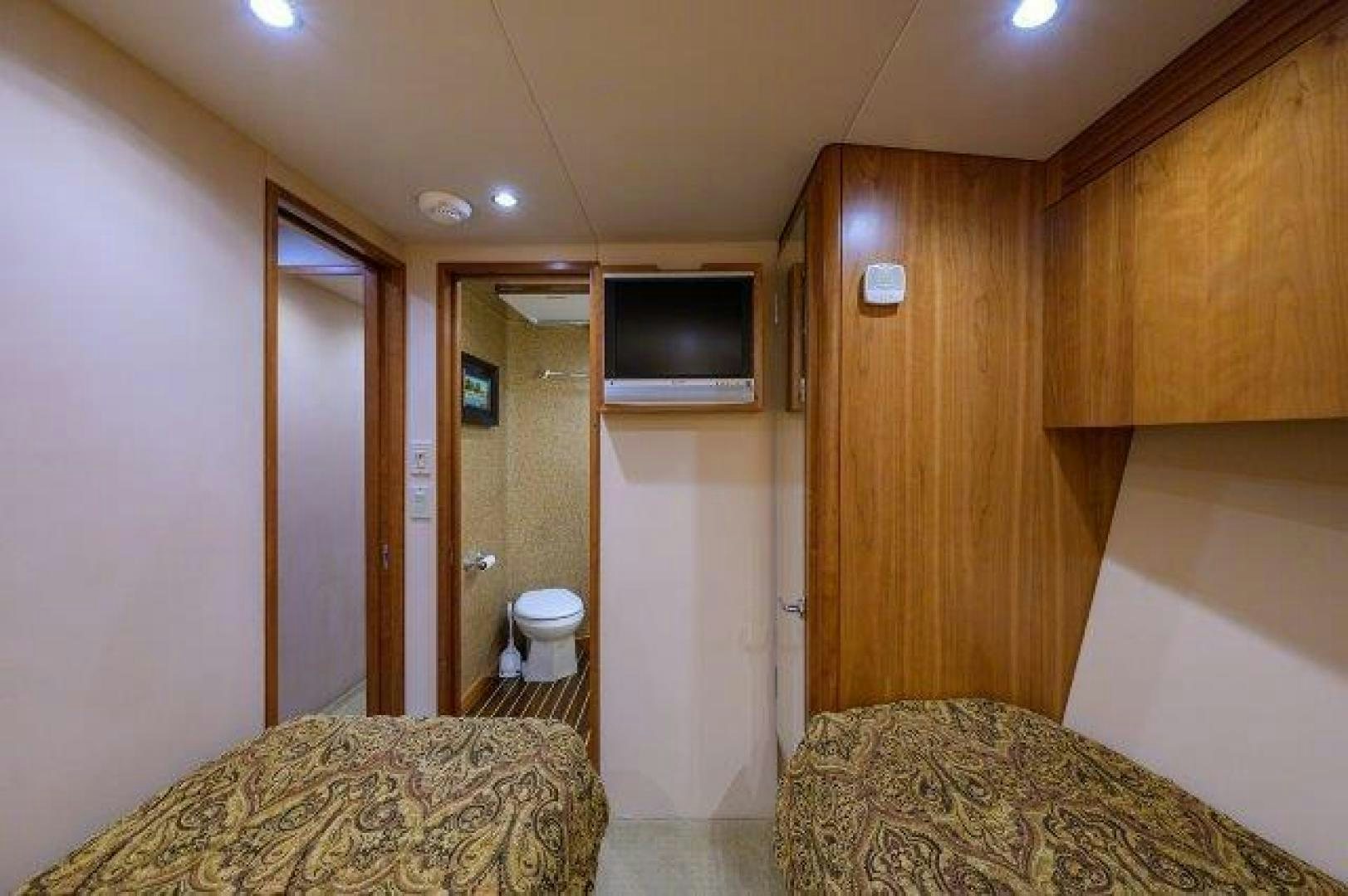 a bedroom with a bed and a television aboard THERAPY Yacht for Sale