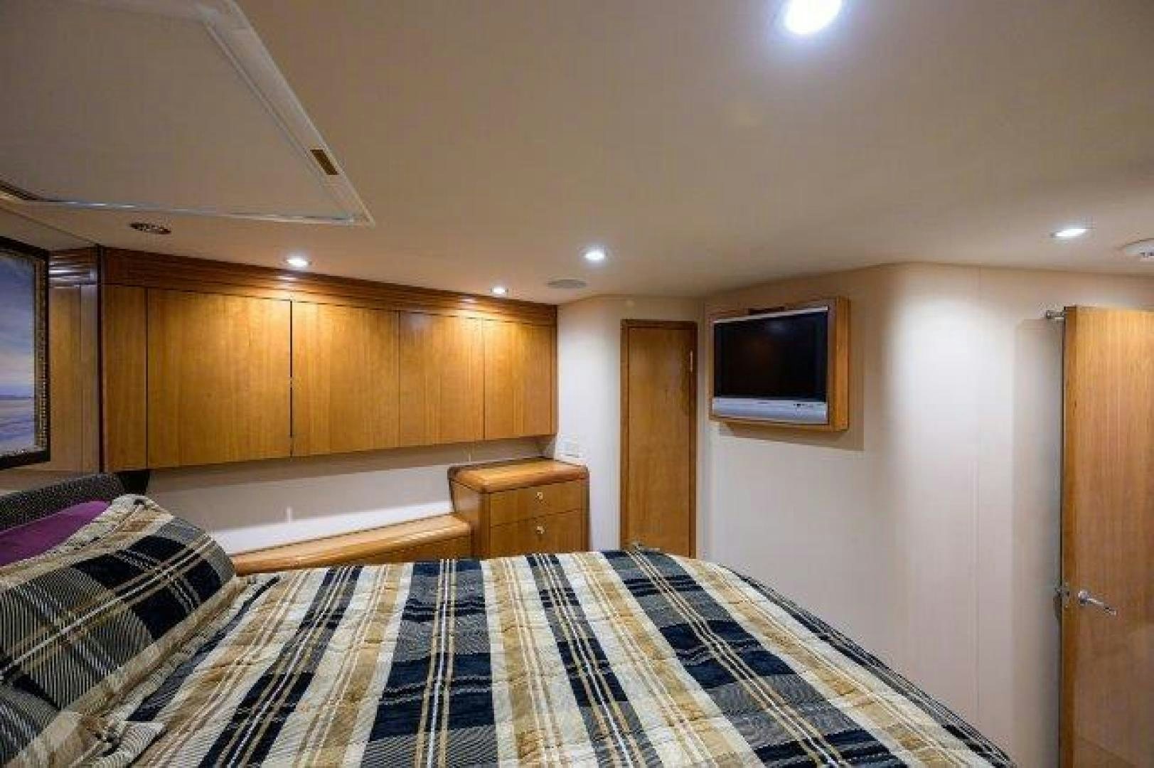 a bedroom with a tv on the wall aboard THERAPY Yacht for Sale