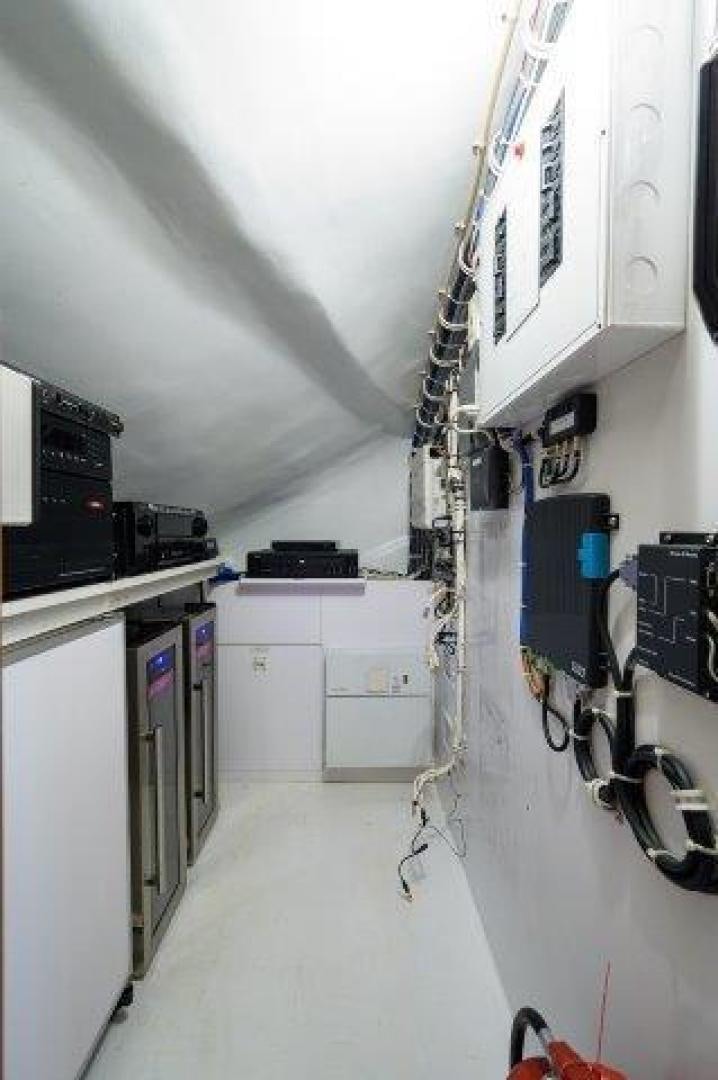 a room with white cabinets and a white wall with a black box on it aboard THERAPY Yacht for Sale