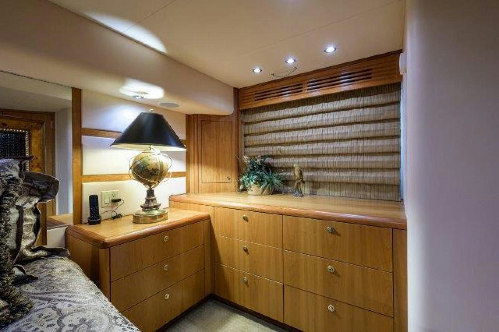 a bedroom with a lamp and a dresser aboard THERAPY Yacht for Sale