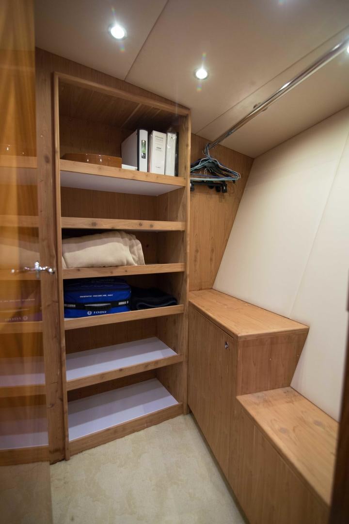 a wooden shelving unit with books and a shelf with books on it aboard PREDATOR Yacht for Sale