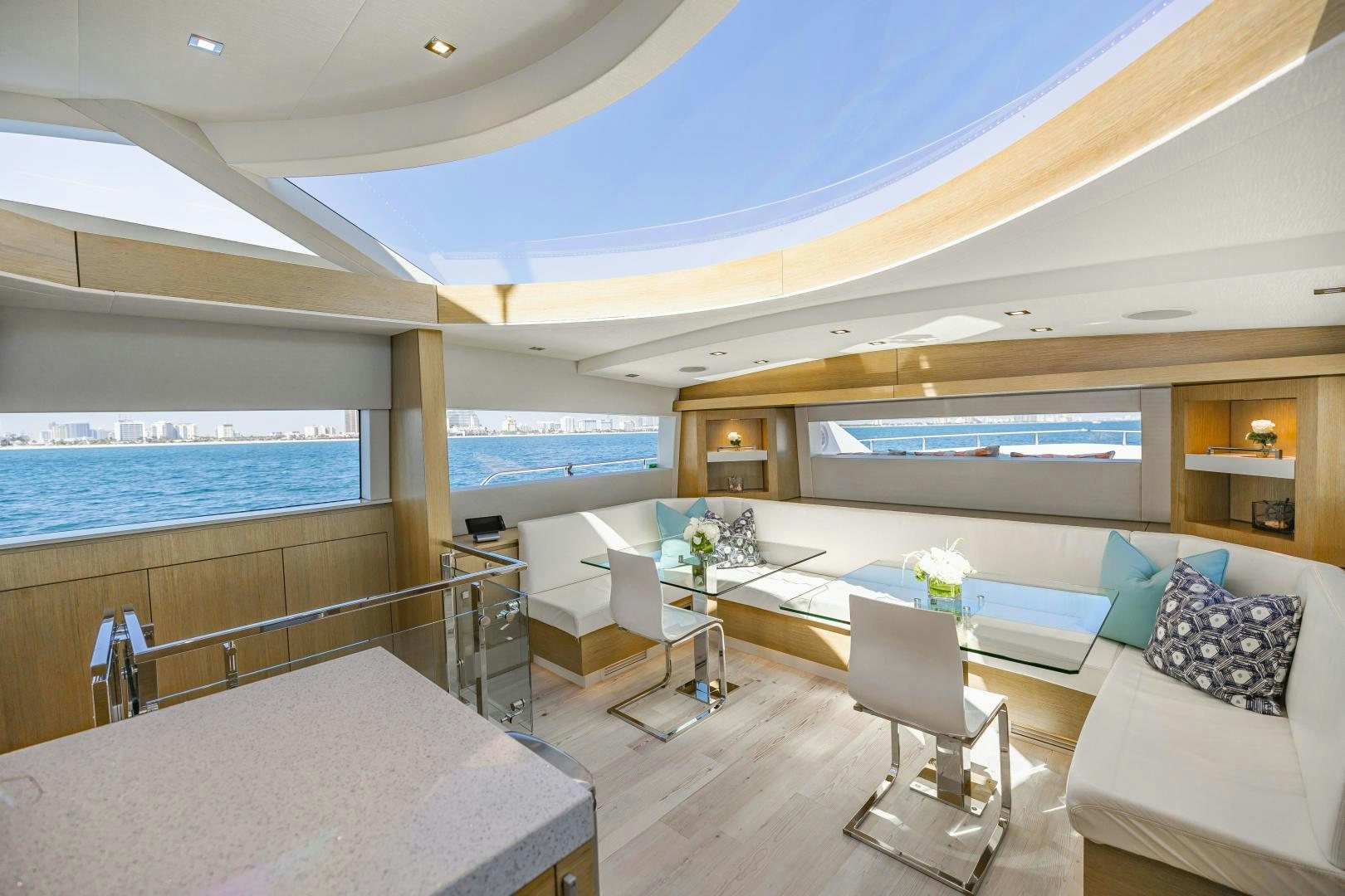 a room with a couch and a table and a large window aboard BELLA SKY Yacht for Sale